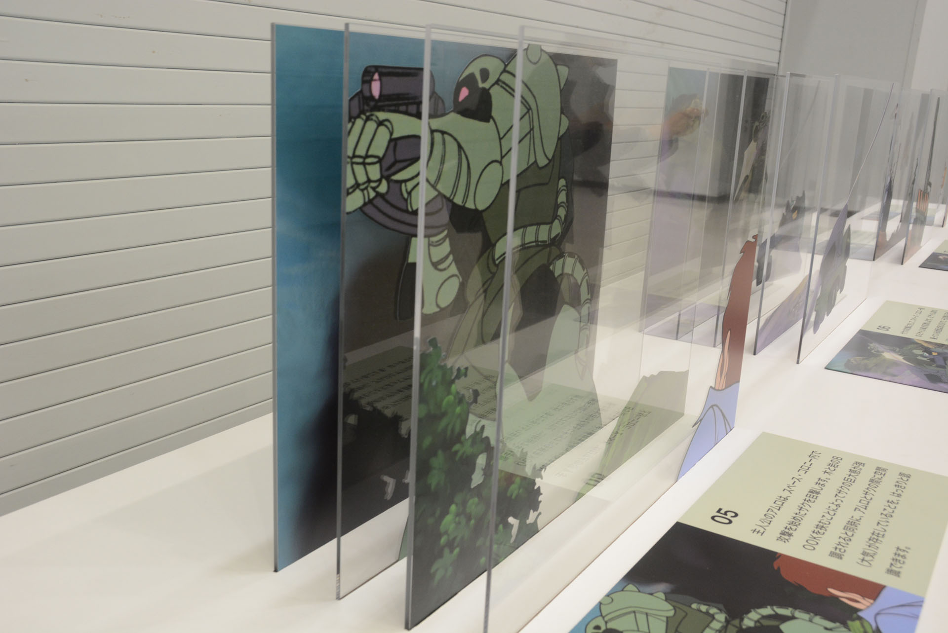 アニメ第一話のセル画を立体的に展示。レイヤーの分け方に"リアル"にこだわる視点が垣間見える