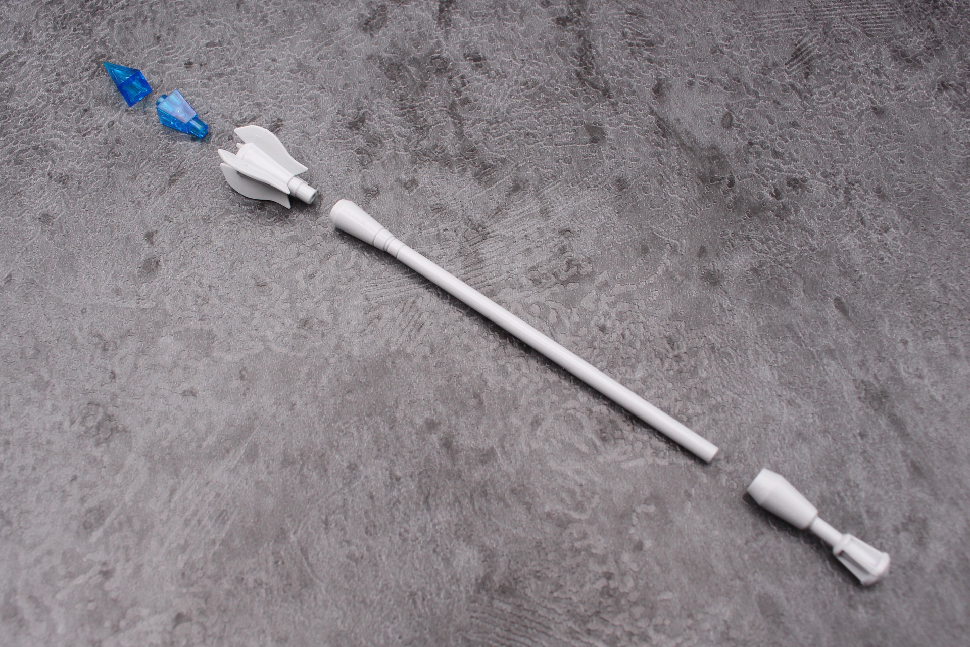 杖の組み立て。先端のクリスタル状の飾りは2パーツの構成。手に持たせるときは手首を通してから下端の飾りを取り付ける