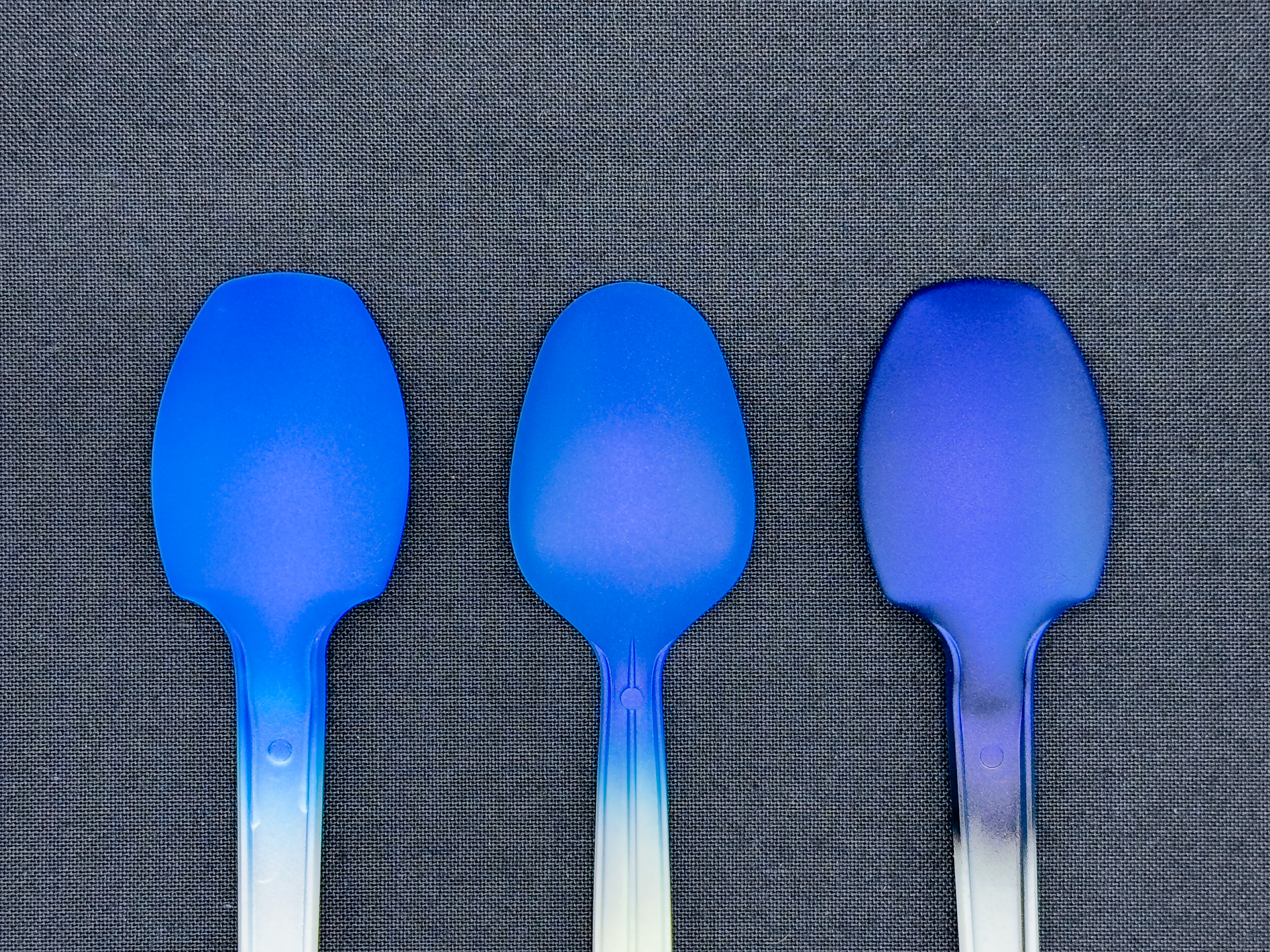 「ベルベットブルー」の発色変化。下地色は左から白、グレー、黒