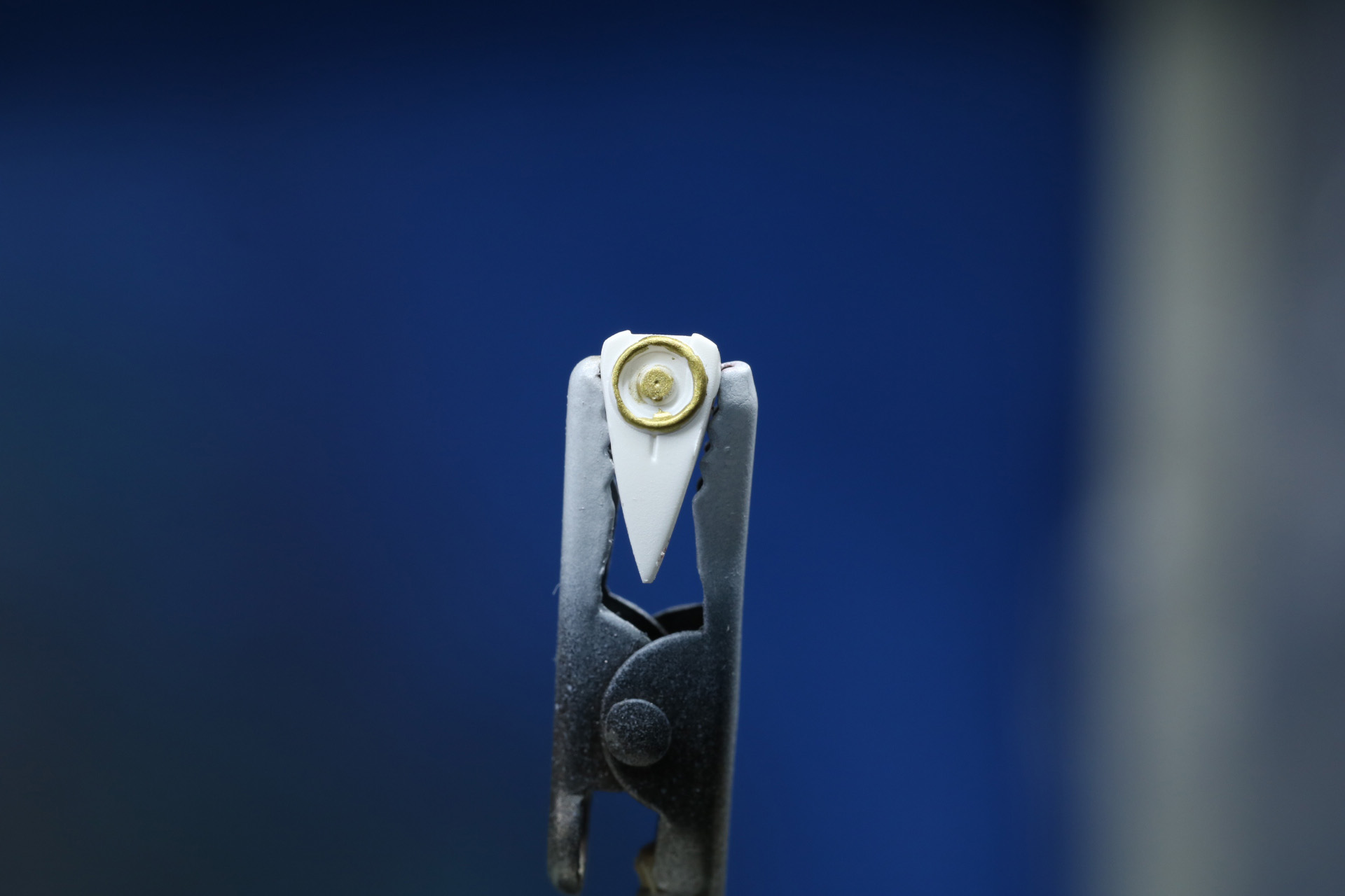 耳のアクセサリは円形の造形に合わせてゴールドを筆塗り