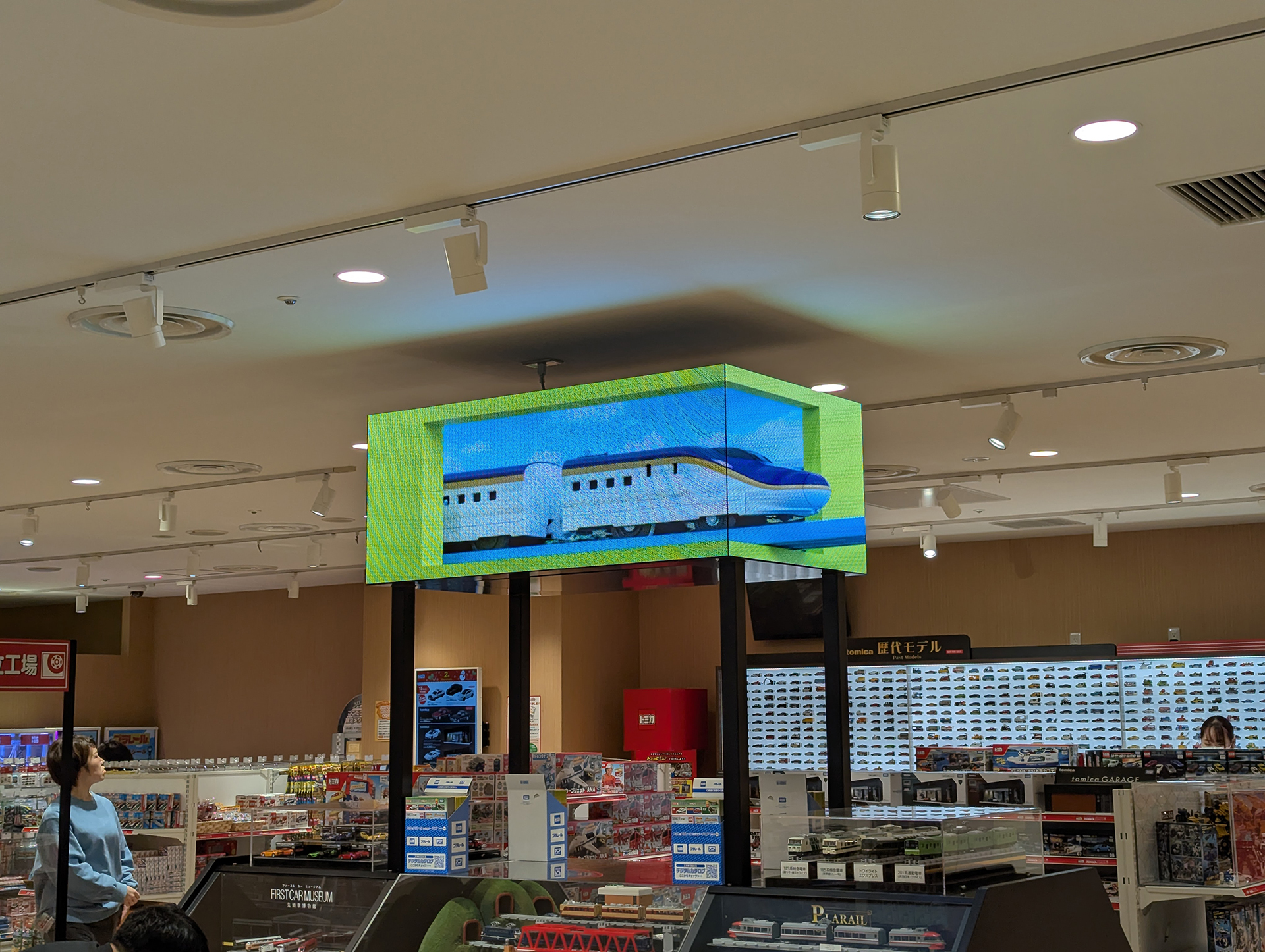 棚の上部には3D大型ビジョンが設置され、あたかもプラレールやトミカが飛び出すような映像が放映されている