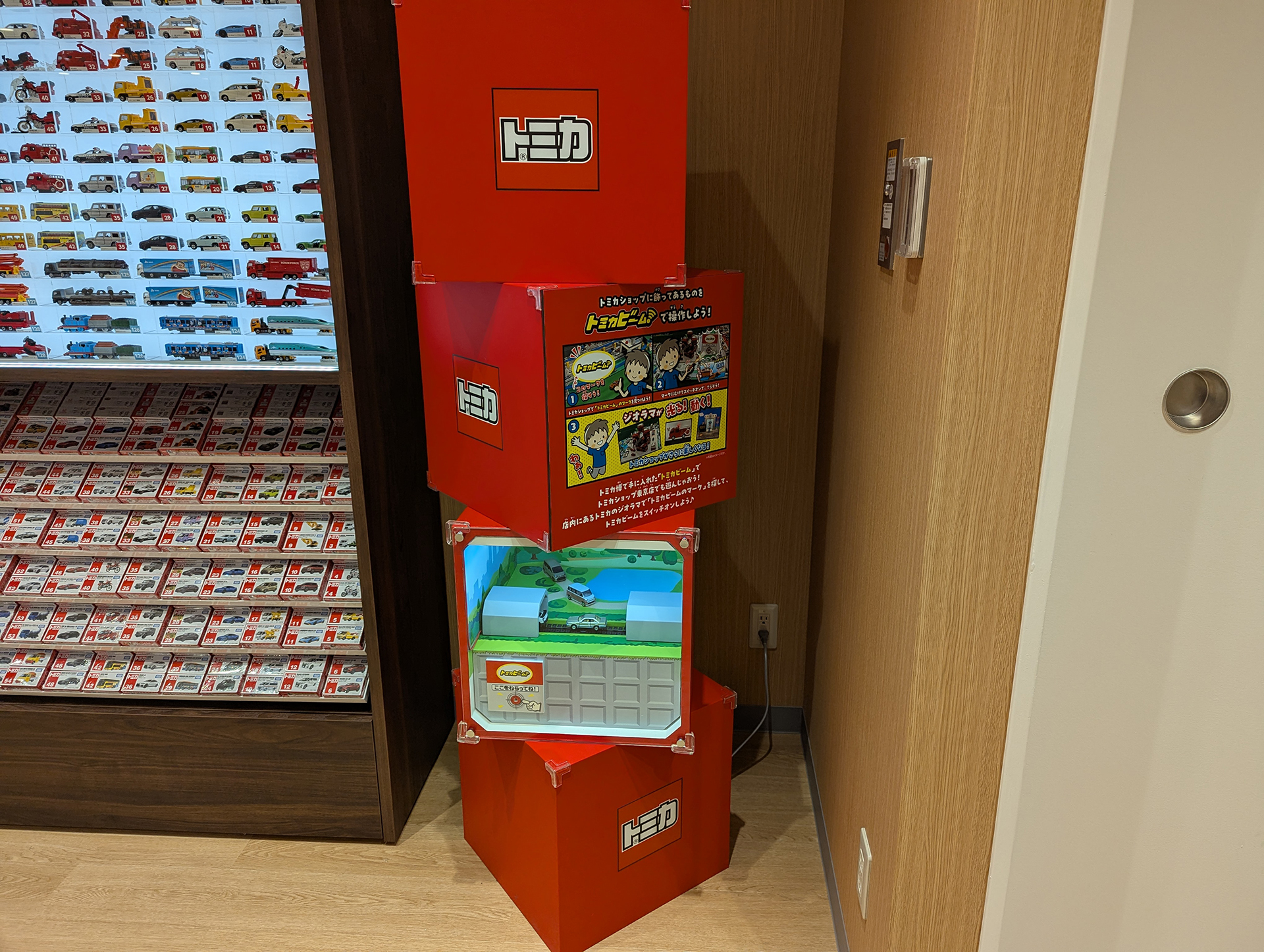 自分の手持ちの「トミカビーム」を持ってきて、ショップの片隅に設置されている、箱型のジオラマにビームを当てる事で、ジオラマ内のギミックが稼働する