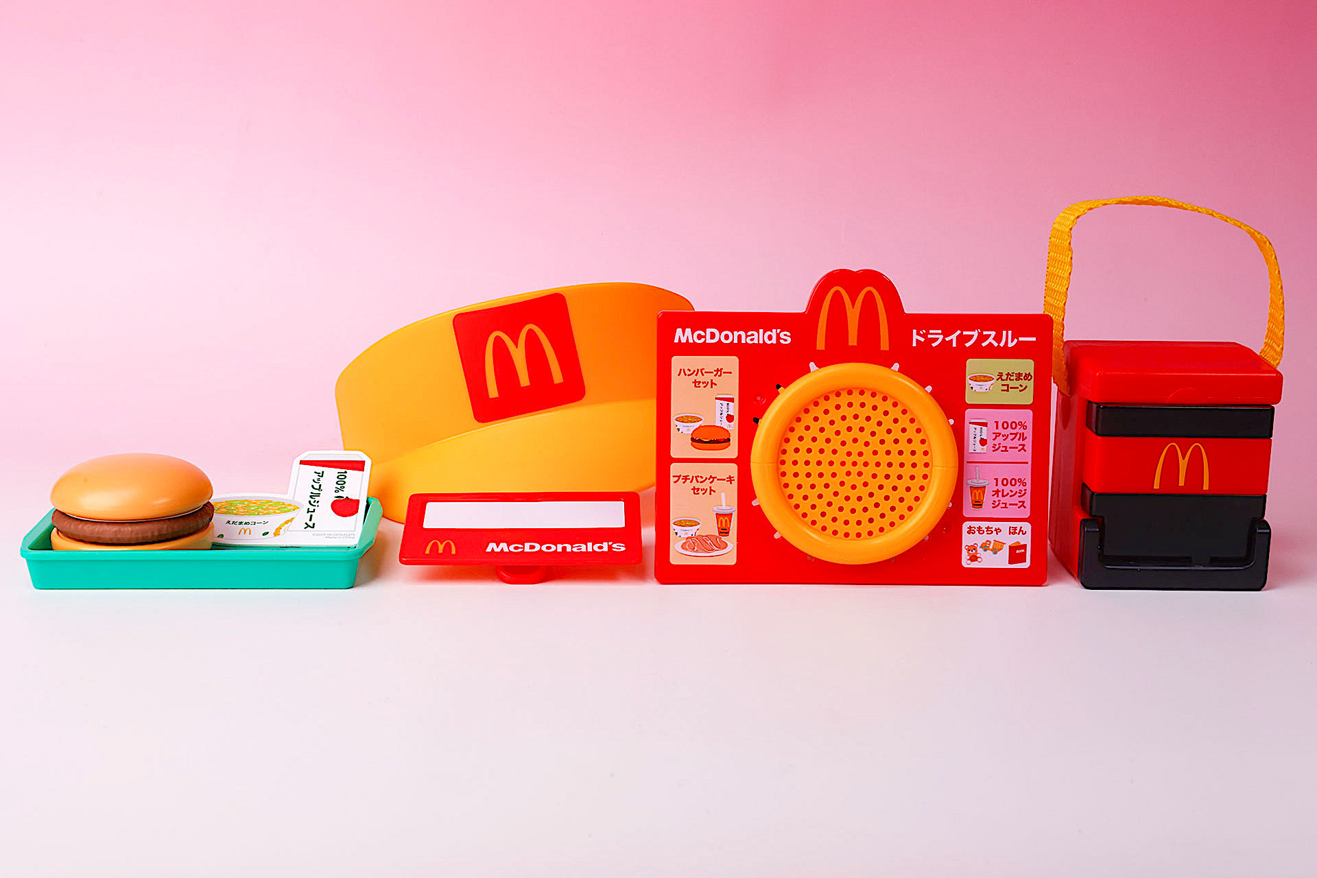 こちらが第2弾（3月7日〜3月13日）のハッピーセット「なりきりマクドナルド」に登場するおもちゃ。写真左から「つくってかんせい！ハンバーガーセット」、「クルーになってみよう！サンバイザー・バッジセット」、「ごちゅうもんをどうぞ！オーダーマイク」、「とどけてあそぼう！デリバリーバッグ」