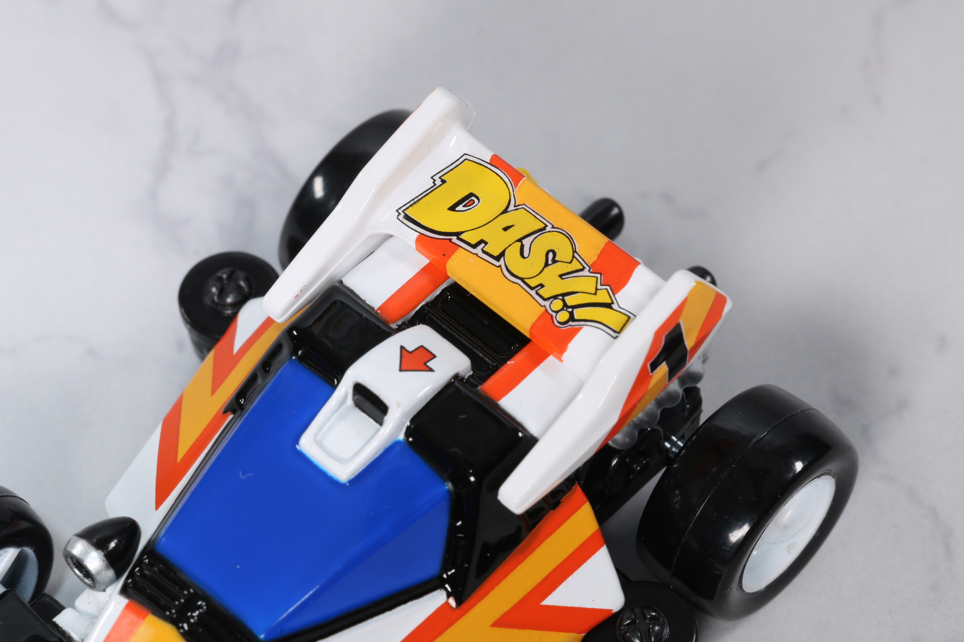 リアの大型ウィングのオレンジとイエローのラインが施されている