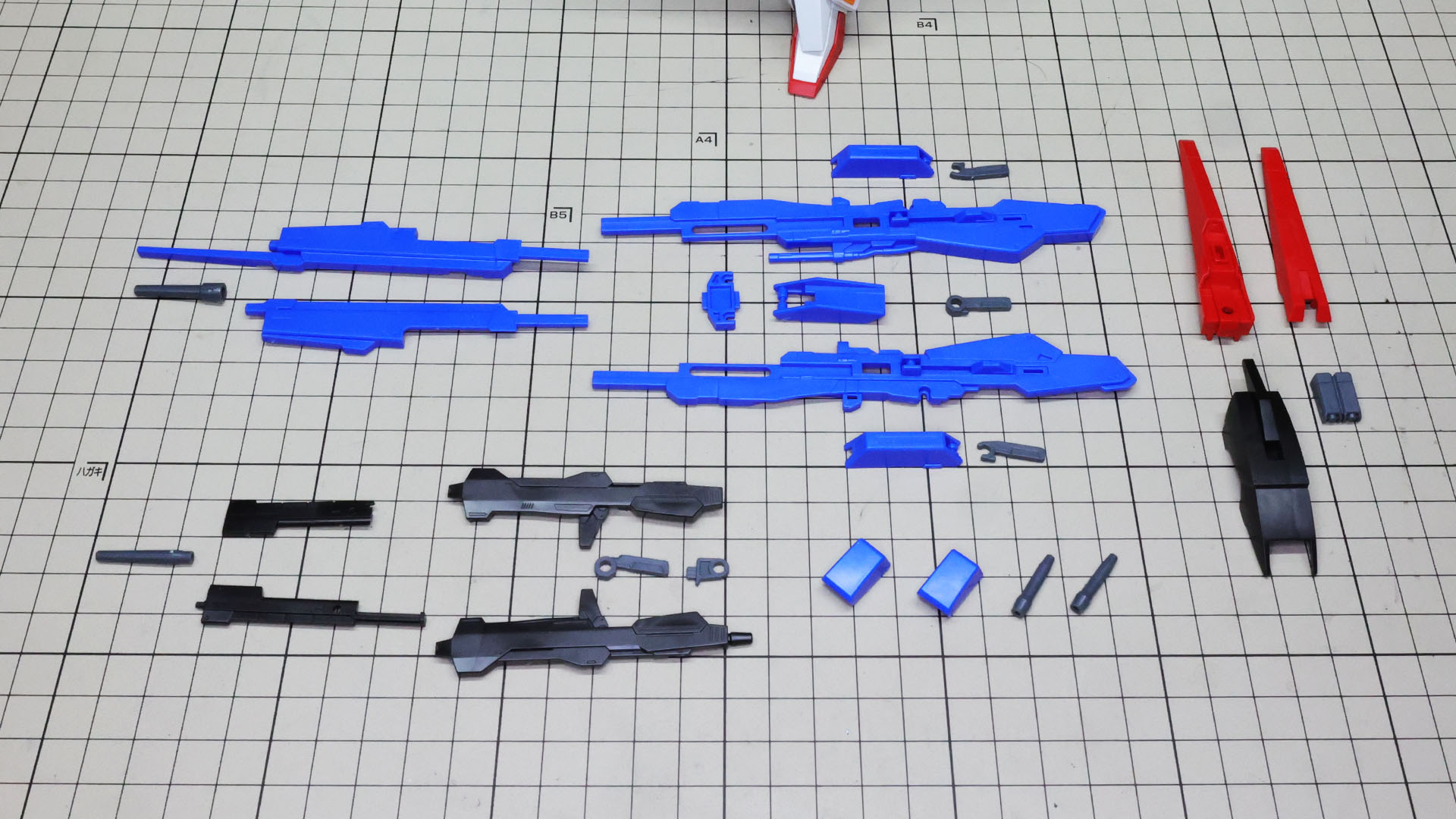 上にハイパー・メガ・ランチャー、右にシールド、左下にビーム・ライフル、右下にグレネード・ランチャー増加カートリッジ、ビーム・サーベルのパーツ群です