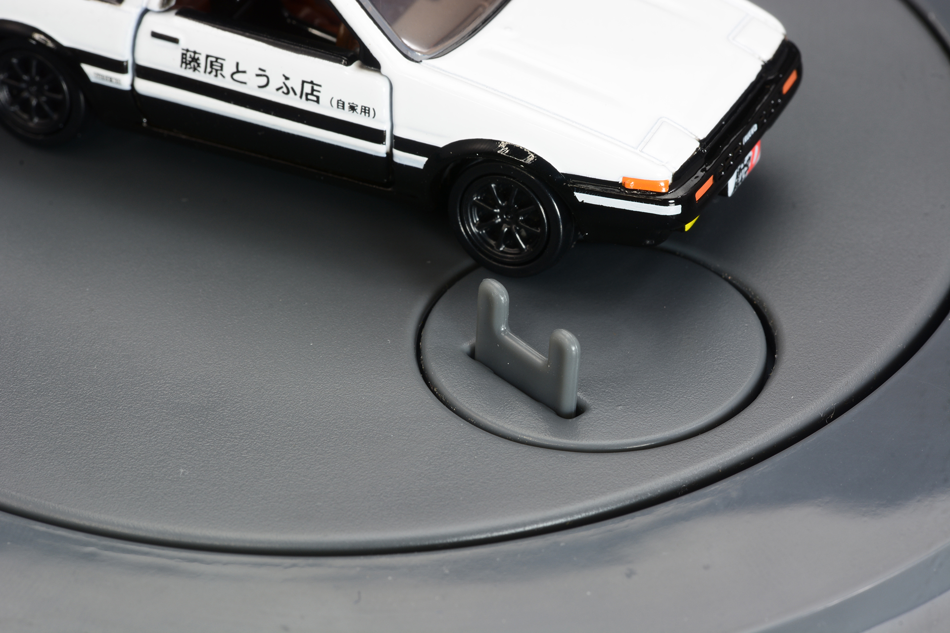 トミカ固定パーツをハチロクの前輪内側にセットし、台に固定する