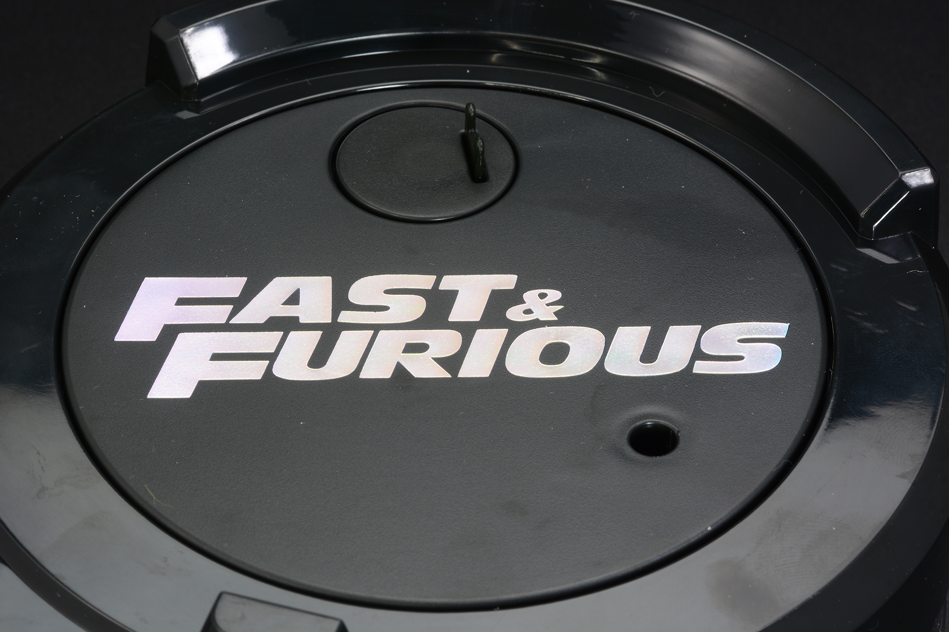 映画の原題である「FAST & FURIOUS」が描かれている。回転することで虹色にキラキラと光る