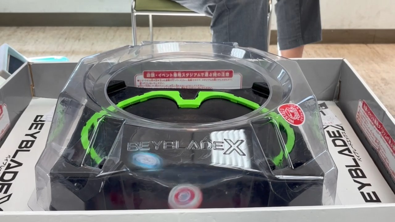 スタジアムの内周部に備えるギア(画像では緑色の部分)を使ってベイが超高速加速「X(エクストリーム)ダッシュ」を行なうのが「BEYBLADE X」シリーズ最大の特徴であり、魅力のアクションだ。写真は筆者のベイがお相手のエクストリームダッシュによりエクストリームフィニッシュを決められたところ
