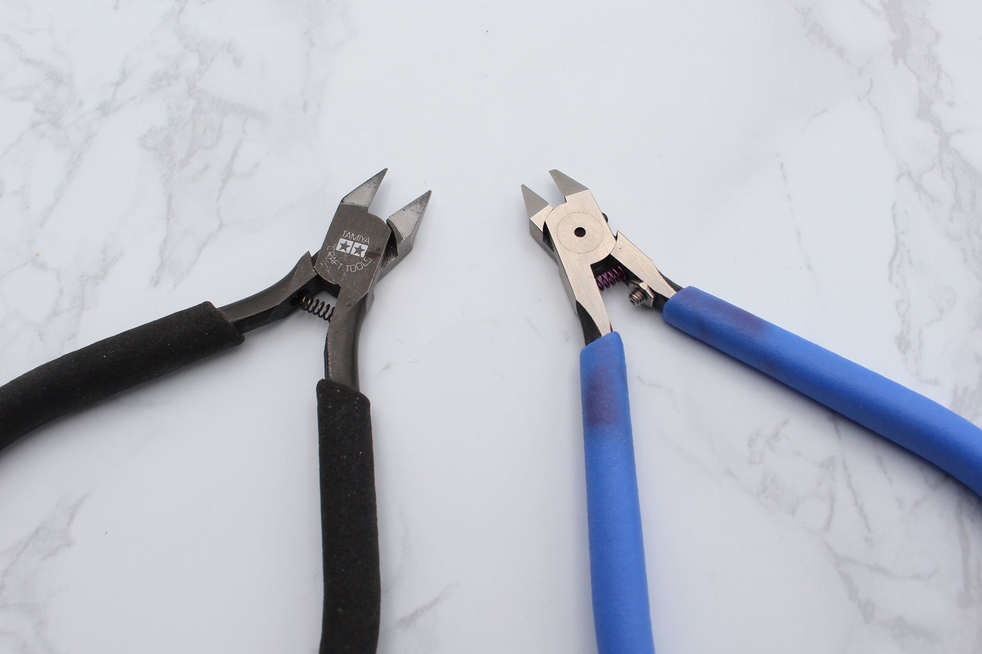左から両刃の「薄刃ニッパー」（タミヤ）と片刃の「アルティメットニッパー」（ゴッドハンド）