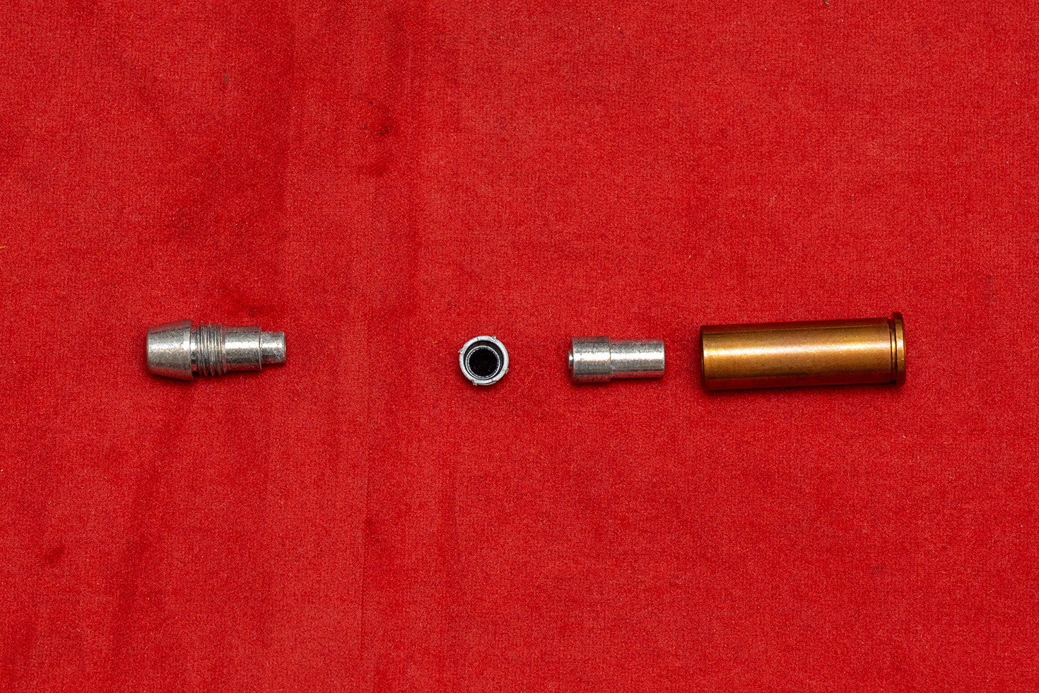 火薬をセットするために分解した様子。プライマー（カートリッジのボトム側インナー）パーツの先端に突起があることで、発火を確実にする工夫が凝らされている