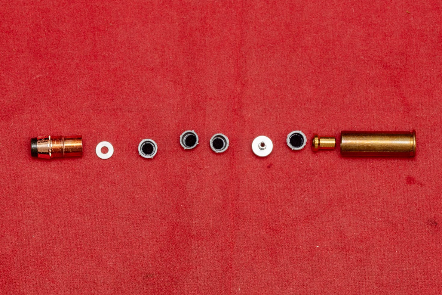 火薬をセットするために分解した様子。発火用として薬莢部に１つ、火花や音など演出用のキャップ火薬を弾頭部のパーツに最大3つセットできる。