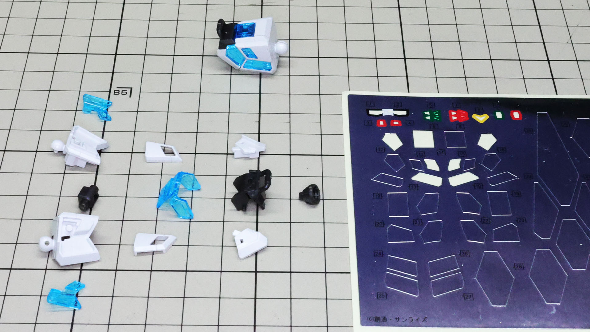 まずは肩アーマー部から！上に完成したもの、下左がパーツ群、下右がシールです