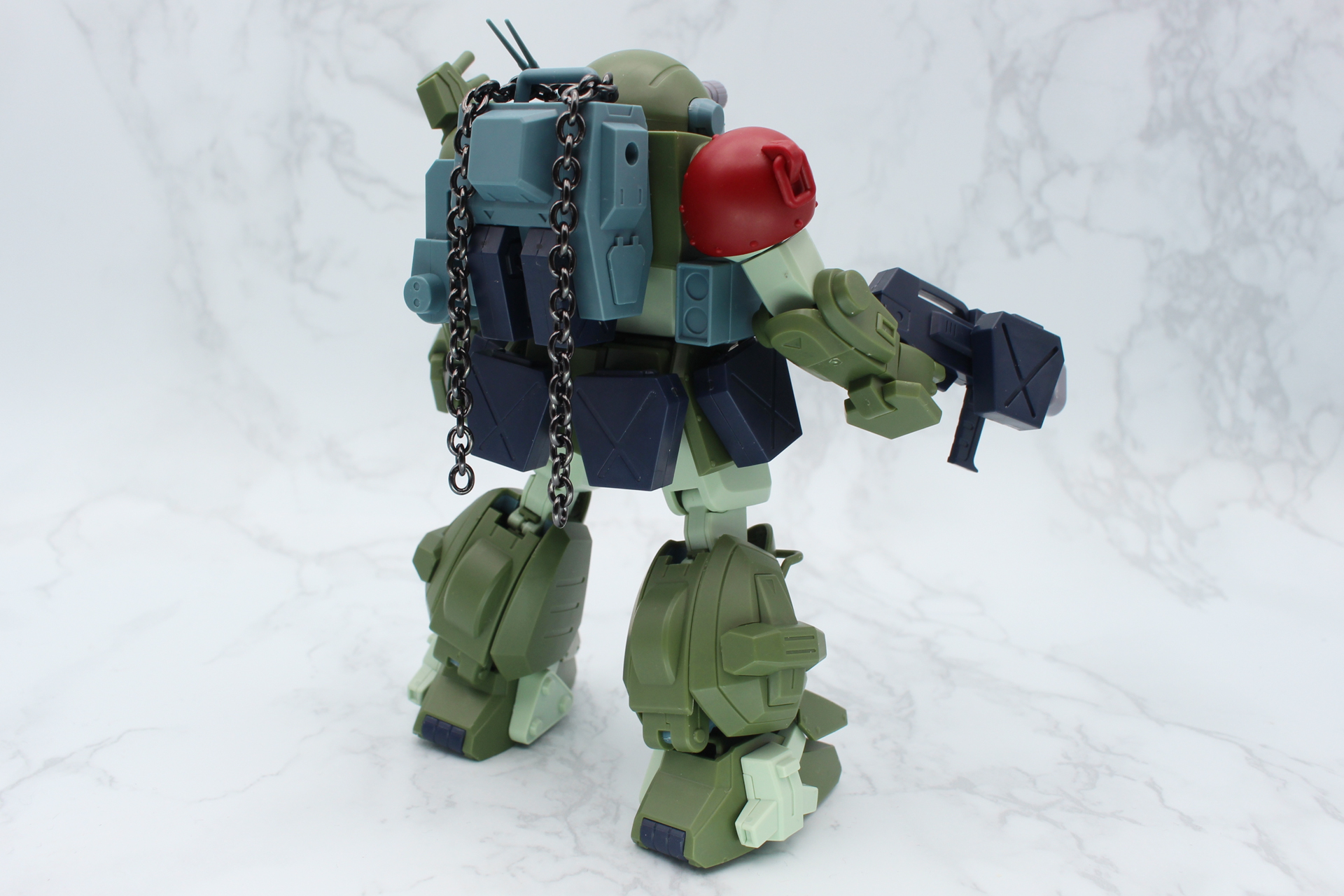 キット付属のカスタマイズ用腰部装甲、「HG バーグラリードッグ」の胸部、拡張パーツセット3のガトリングガンと予備マガジンを使用。チェーンは「カスタマイズマテリアル（チェーンパーツ/マルチジョイント）」のものだ