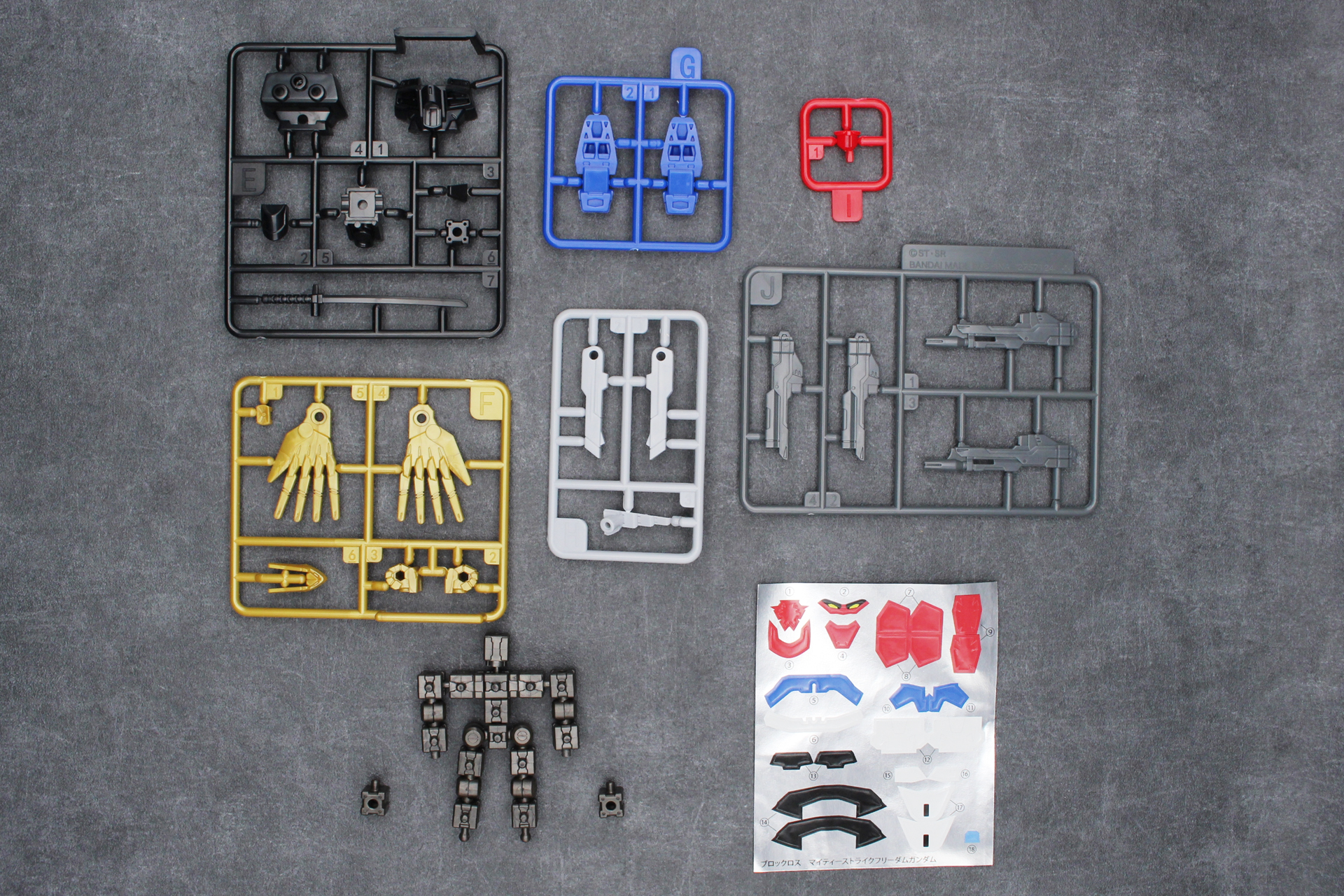 「ブロックロス マイティーストライクフリーダムガンダム」の内容物。ランナーA～J、ブロックフレーム、ブロックの予備2個、シール