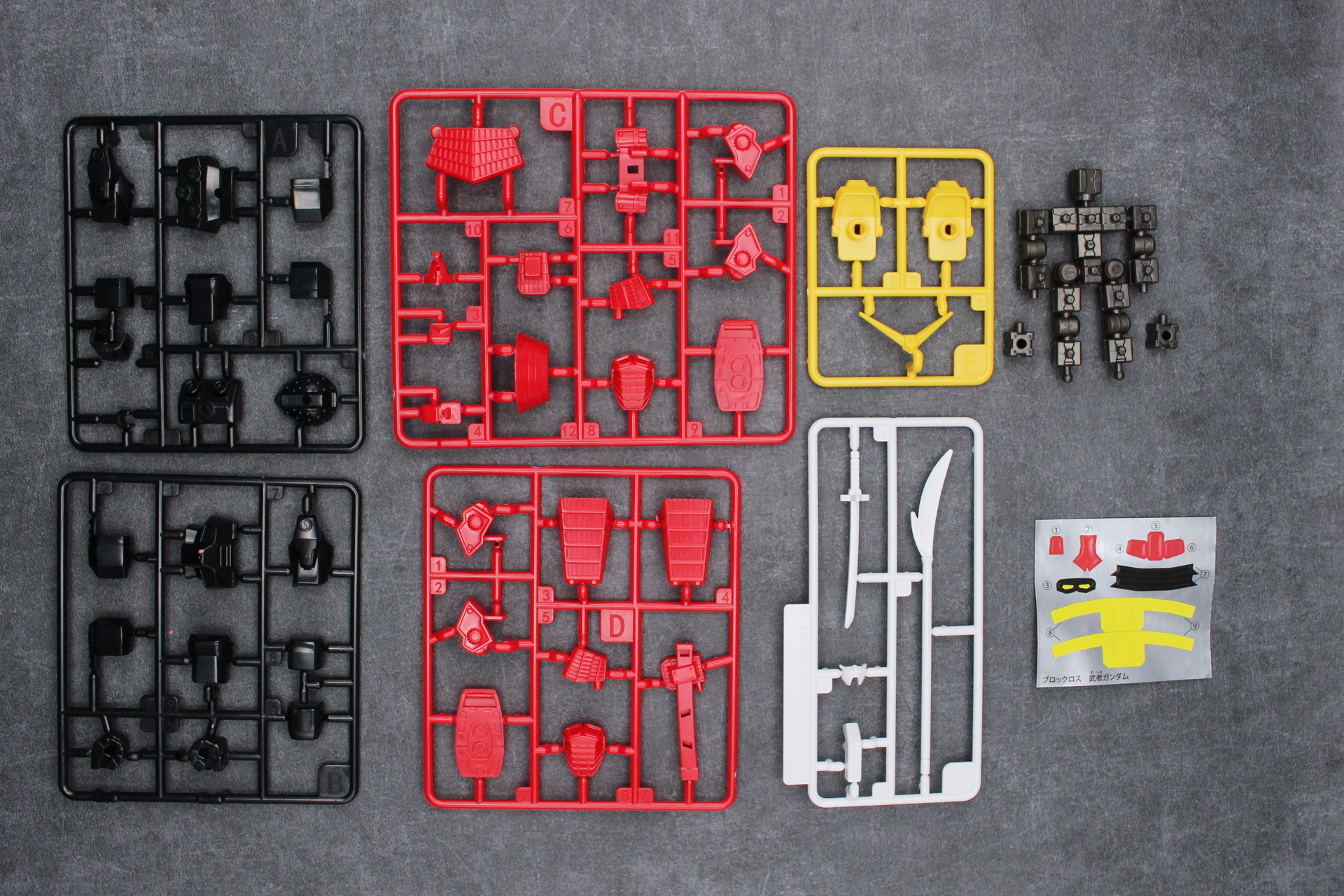 「ブロックロス 武者ガンダム」の内容物。ランナーA～F、ブロックフレーム、ブロックの予備2個、シール