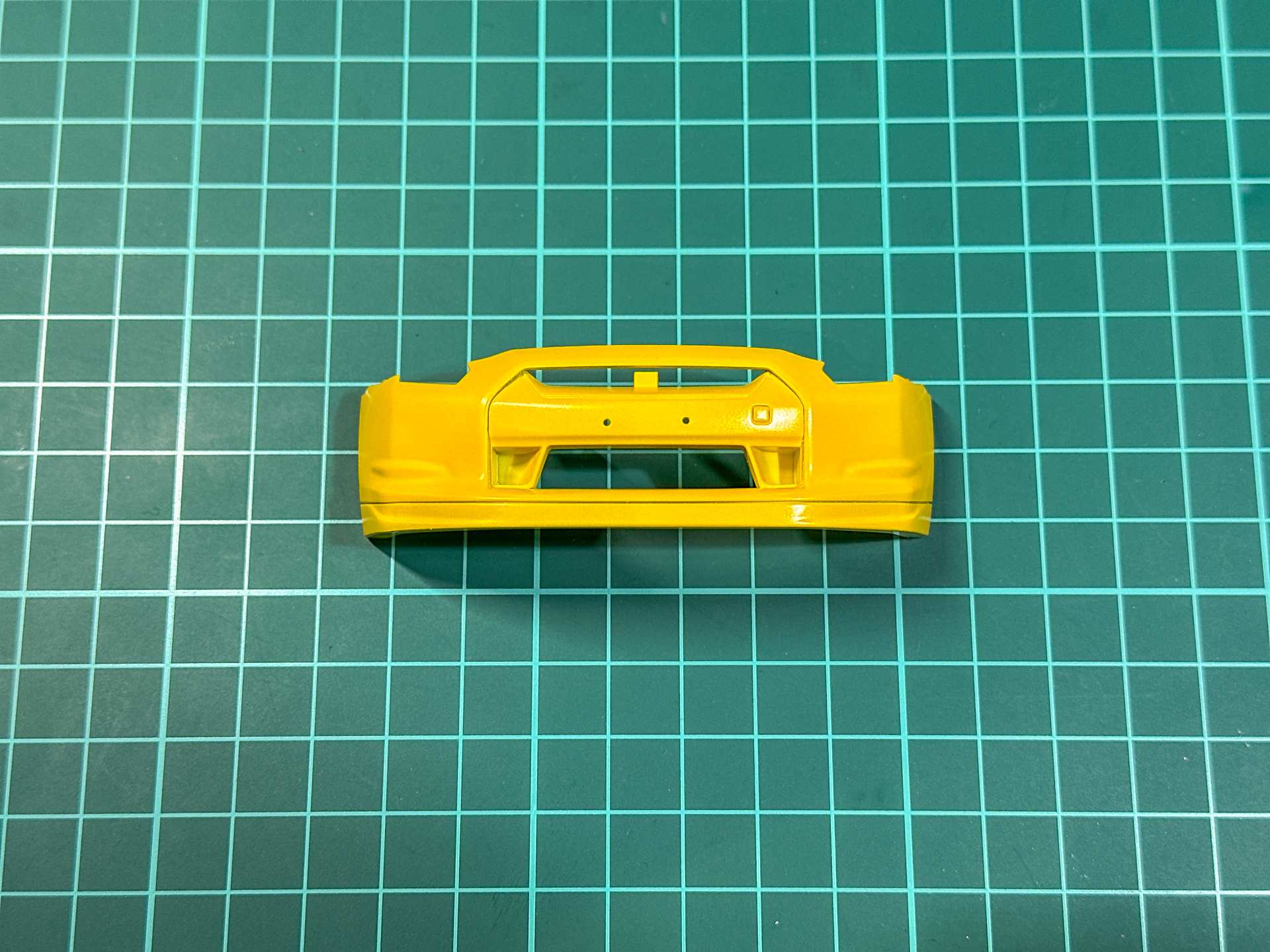 パールイエローを塗布したフロントバンパー。中央部分は後ほど塗分けを行ないます。