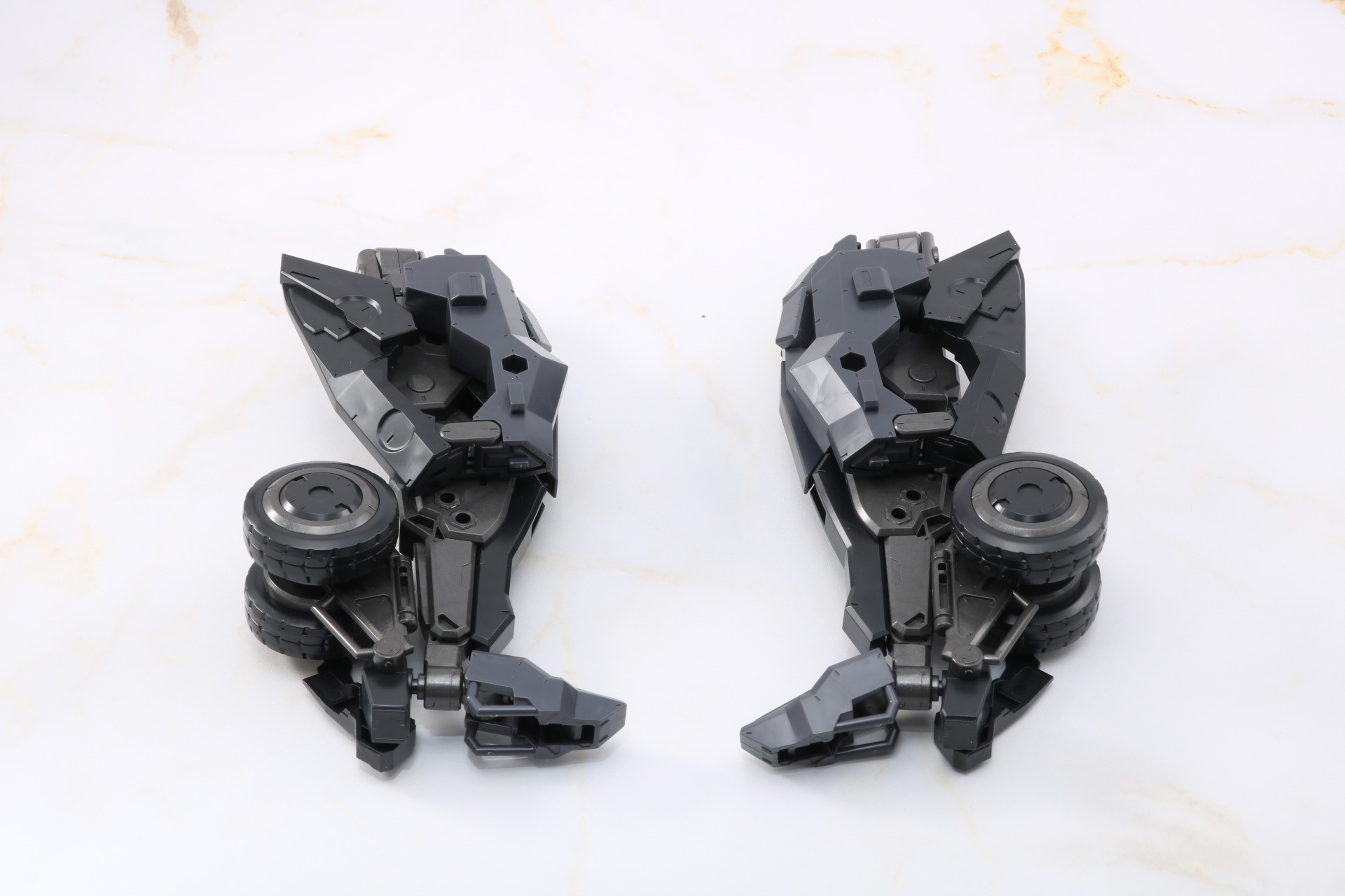 脚部の変形。前輪パーツが展開、4輪タイヤを覆う武骨なフェンダー、足先のヘッドライトが展開