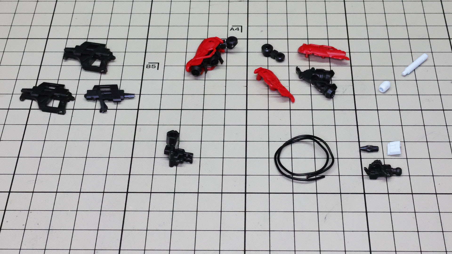 左上：ライフル、中央上：バックパック（背部スラスター）、中央下：マウント、右上：サーベル、右下：ワイヤー（リード線）＆ハンドのパーツ群。一部組み立てています