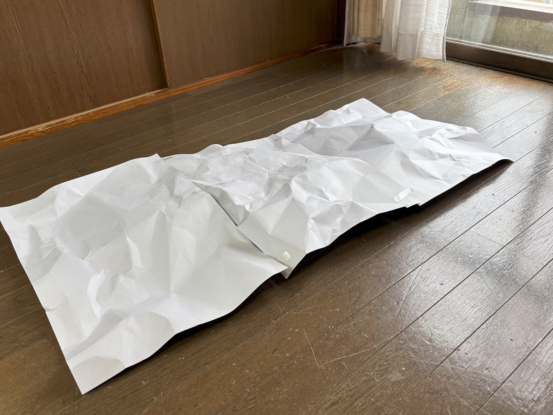 しわをつけた画用紙をかぶせる。画用紙数枚をテープで貼り付けて面積を広げる