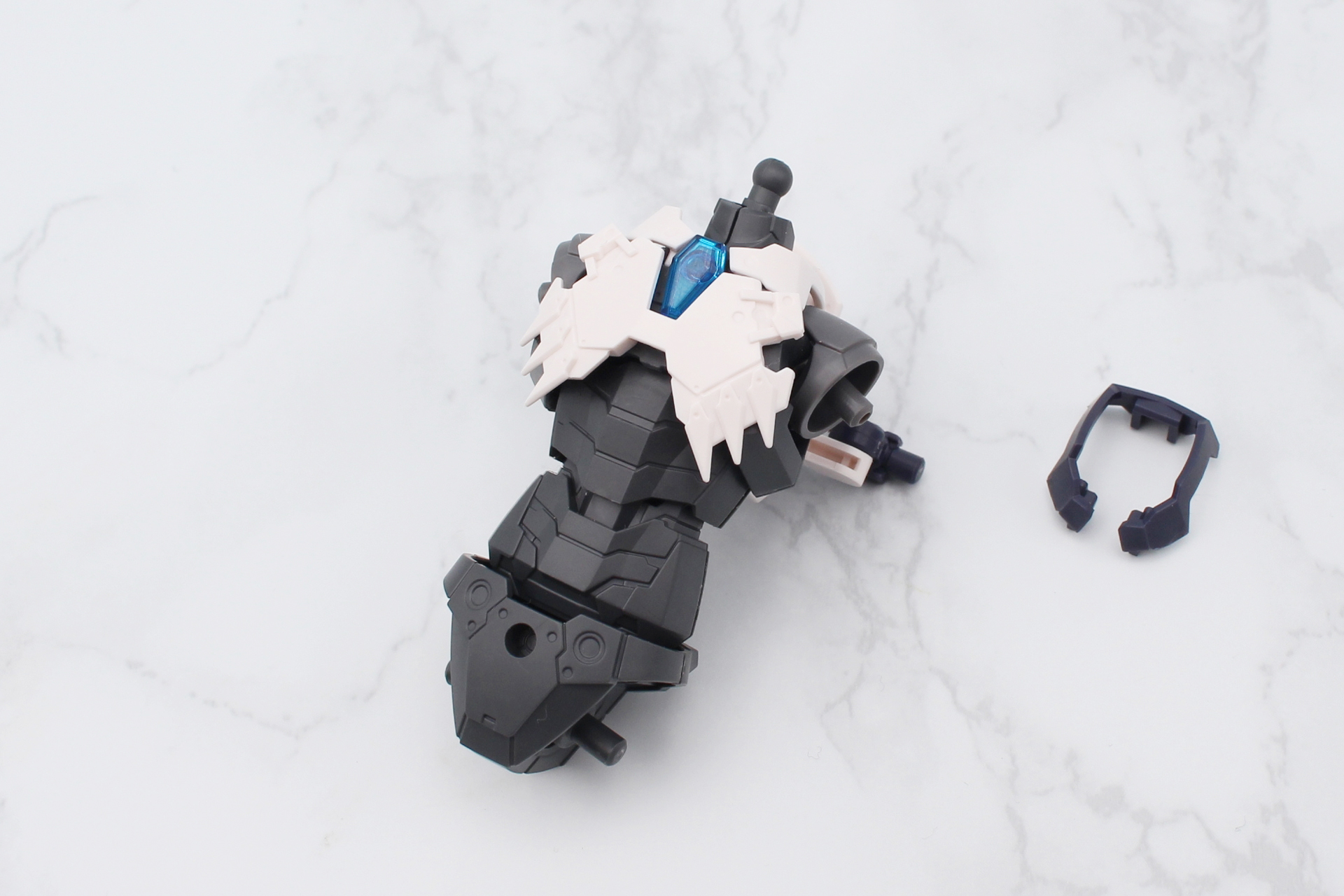 首と胸のアーマーを取り付ける。シルエットの首回りのパーツ（写真右）の取り外しは慎重に