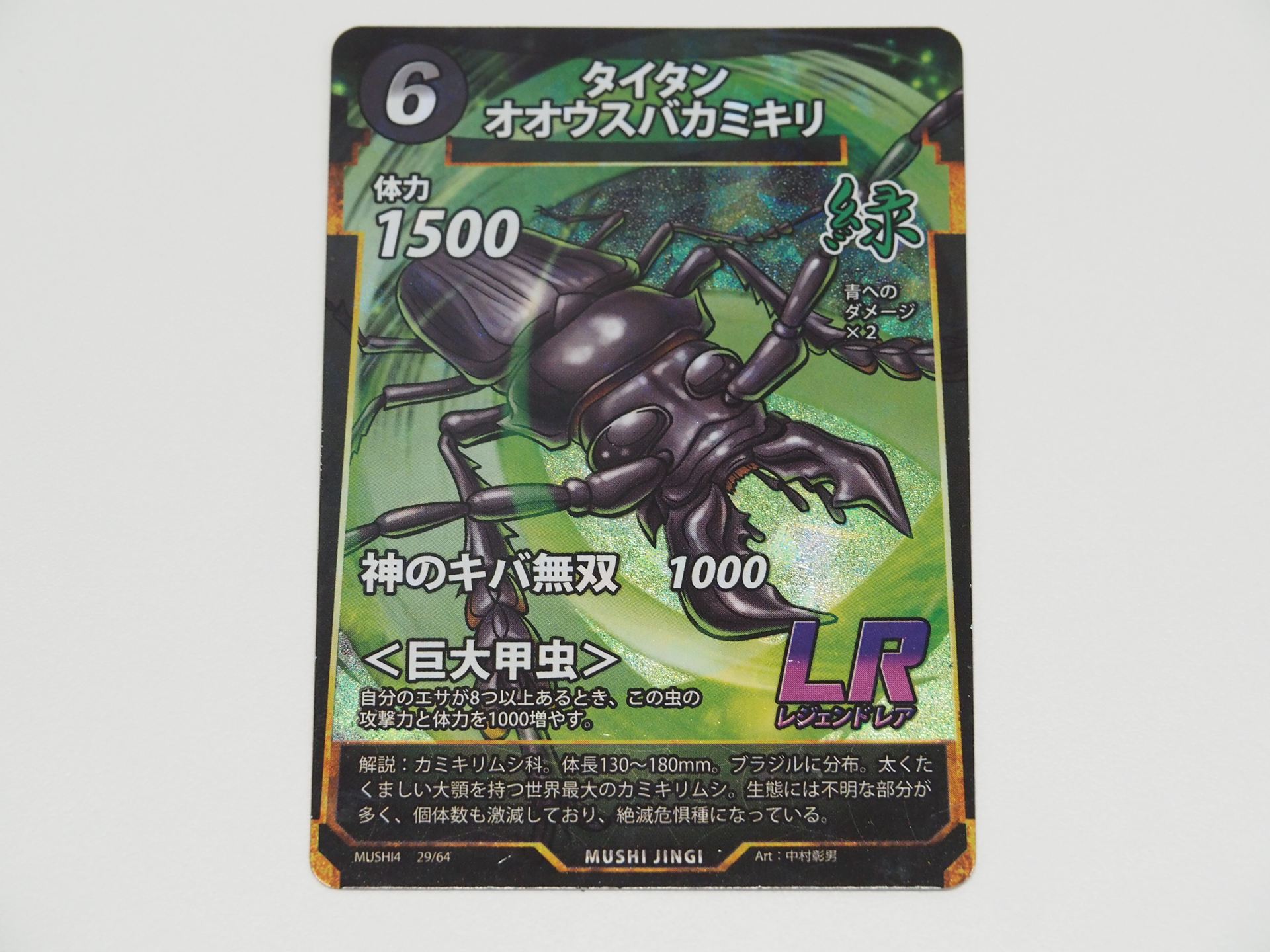 緑6コストのLRカード「タイタンオオウスバカミキリ」。第4弾で登場したカード。エサが8つ以上あれば、体力と攻撃力が1000増える＜巨大甲虫＞を持つ