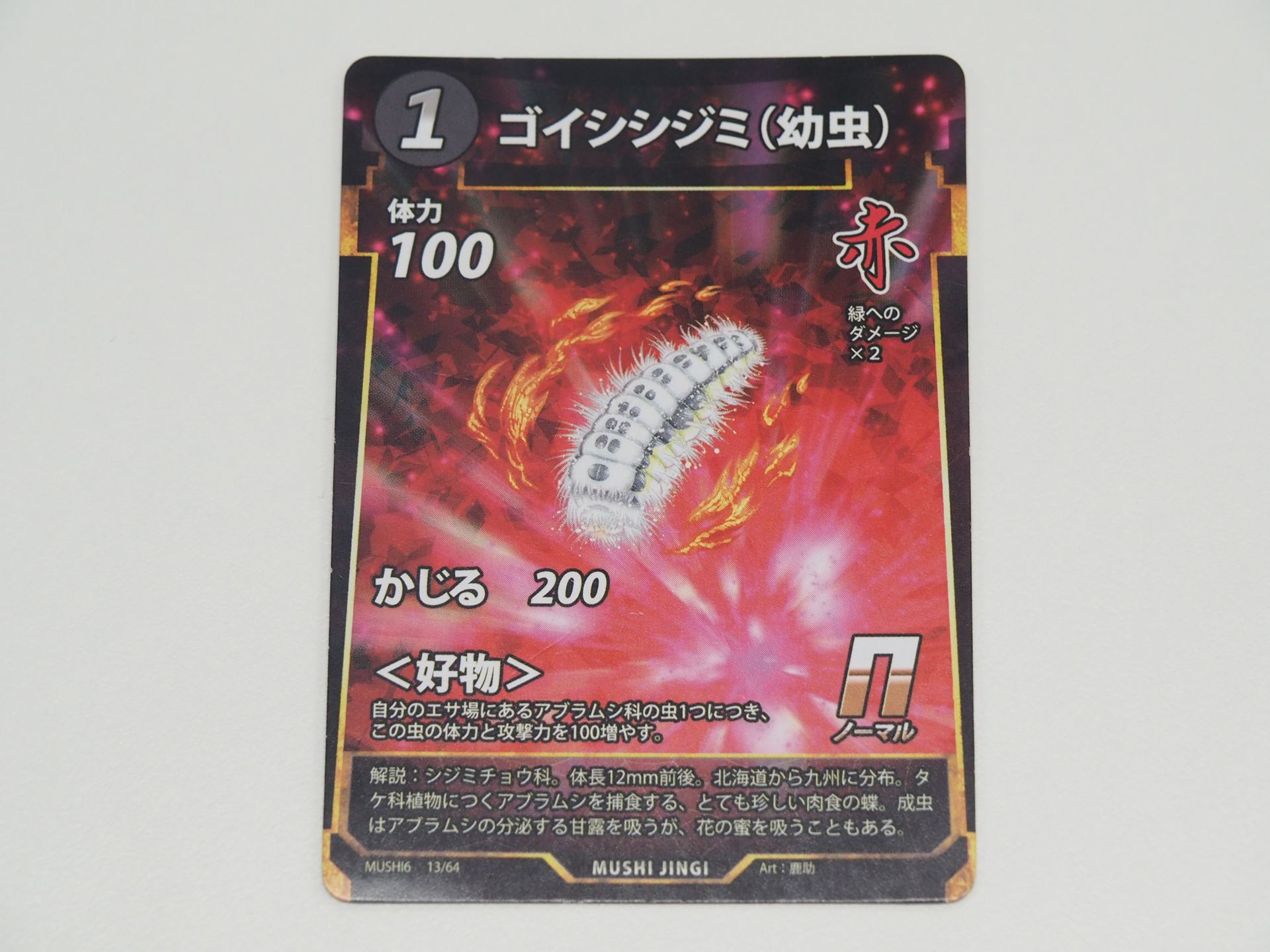 赤1コストのNカード「ゴイシシジミ（幼虫）」。先行体験会で初出のカード。自分のエサ場にあるアブラムシ科の虫1つにつき、体力と攻撃力を100増やす＜好物＞を持つ