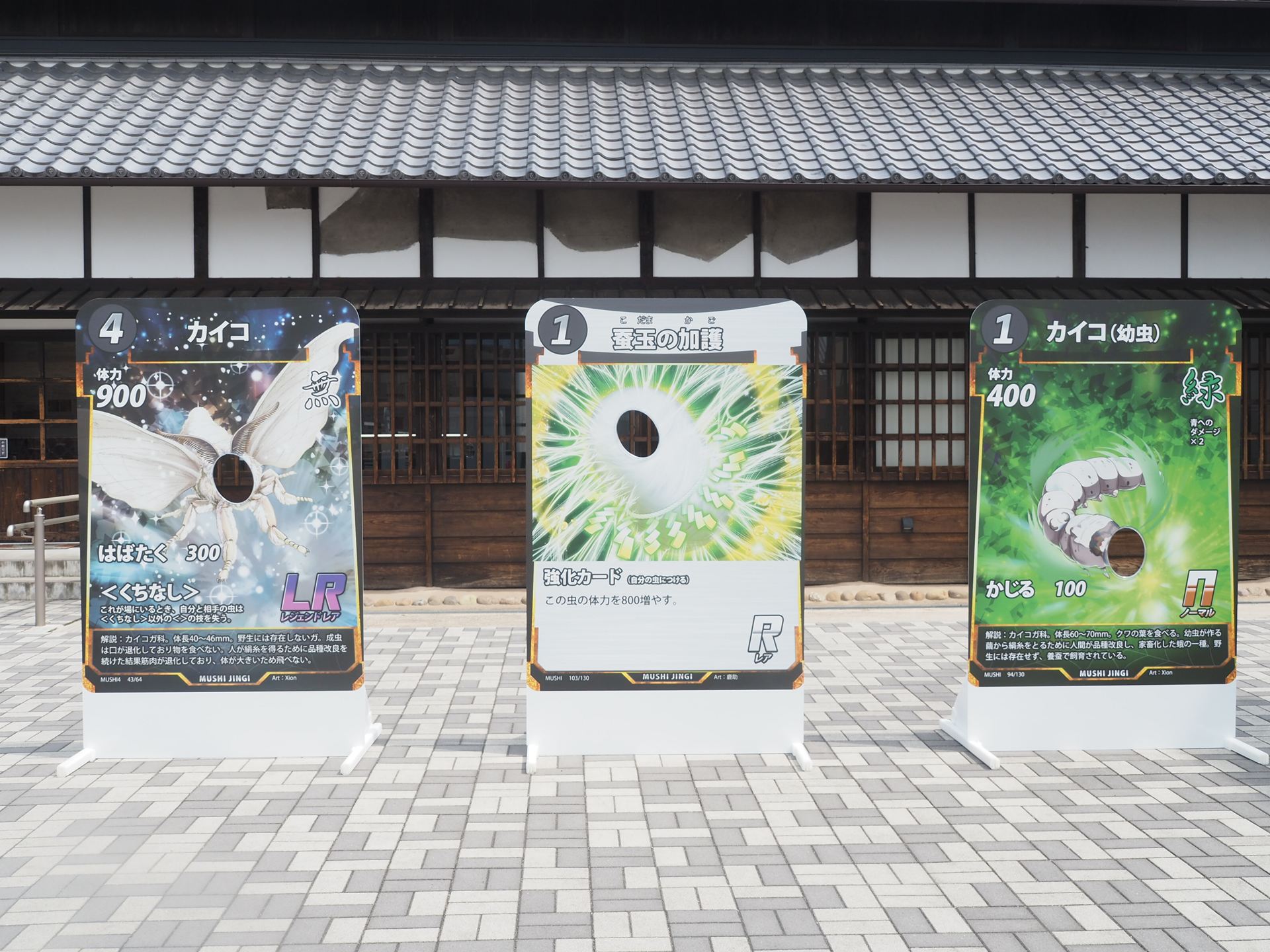 広場に蟲神器カードの顔出しパネル3種類が置かれている