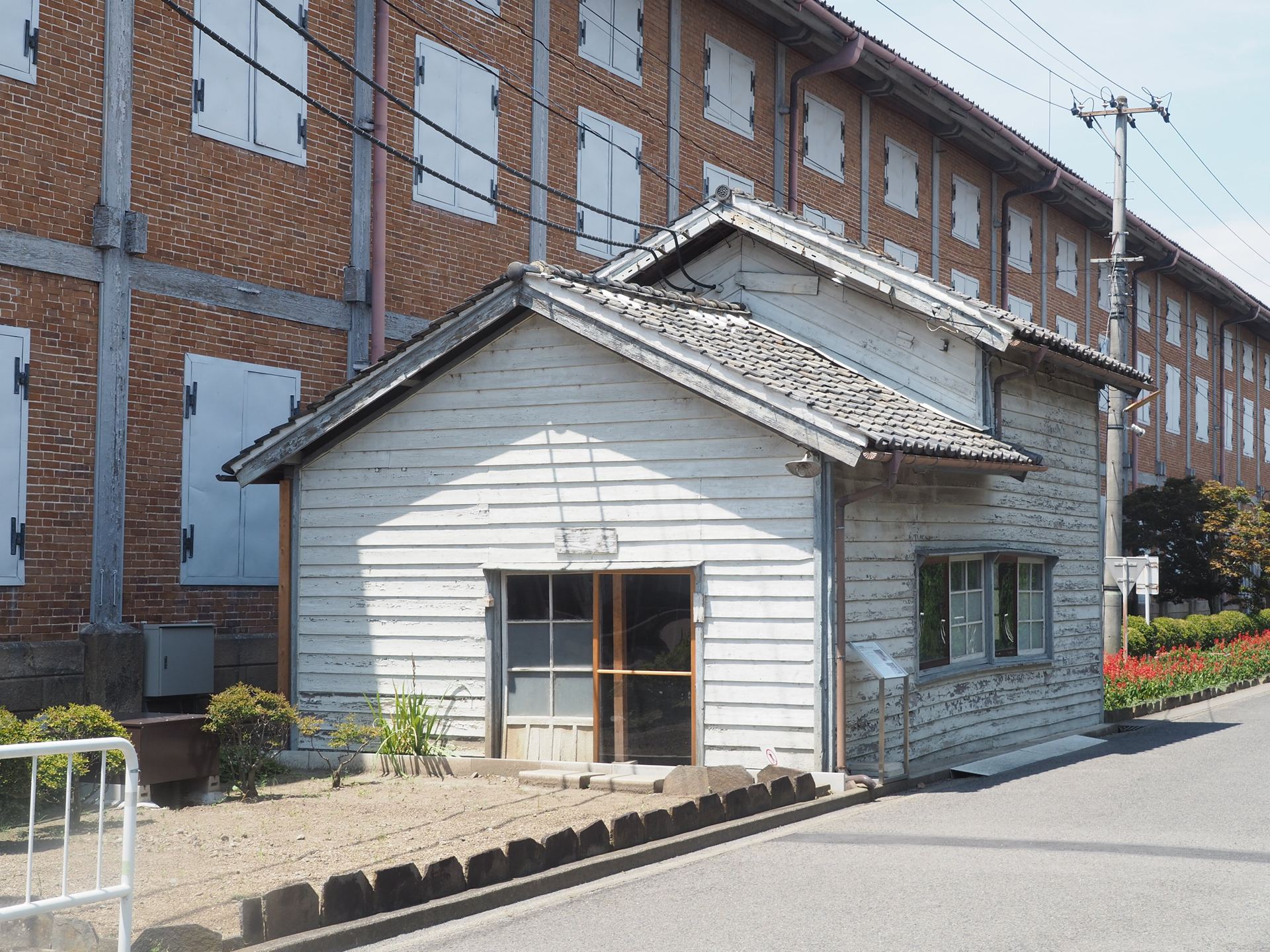 白い木造建物は高圧変電所である