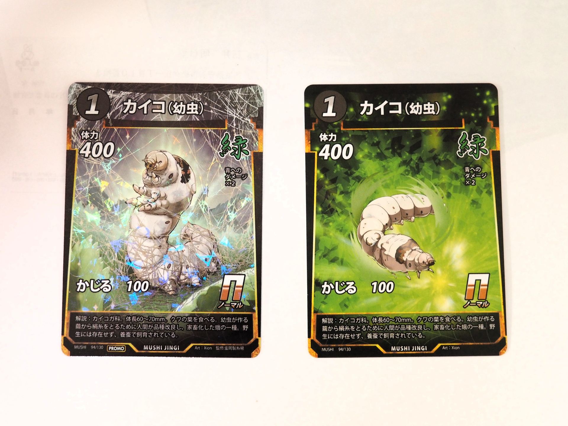左がイベント限定プロモカードの「カイコ（幼虫）」。右が通常の「カイコ（幼虫）」。限定プロモカードはイラストが違うだけでなく、キラ加工もされており、美しい