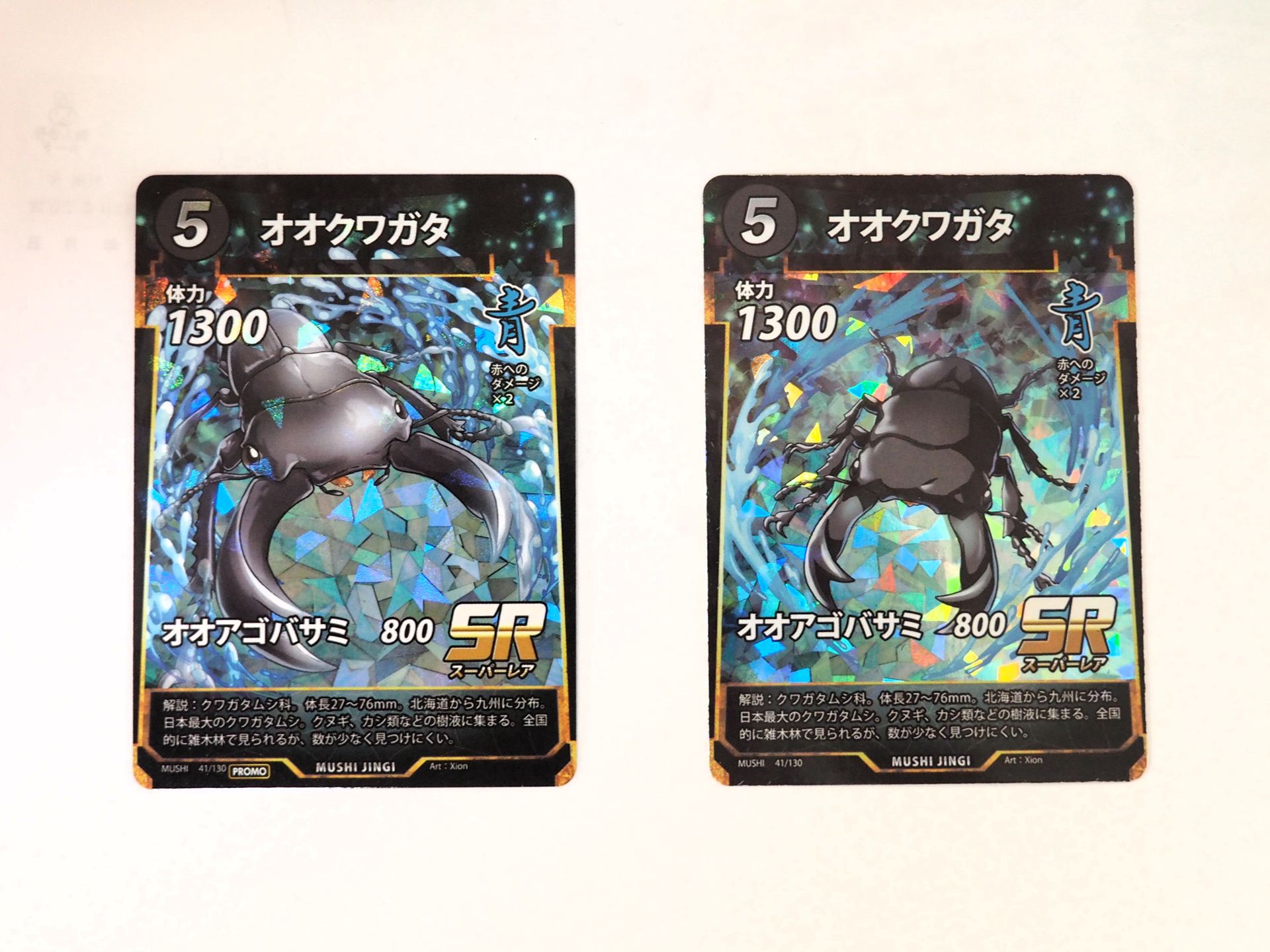 左がイベント限定プロモカードの「オオクワガタ」。右が通常の「蚕玉の加護」。どちらもキラ加工はされているが、イラストが異なる