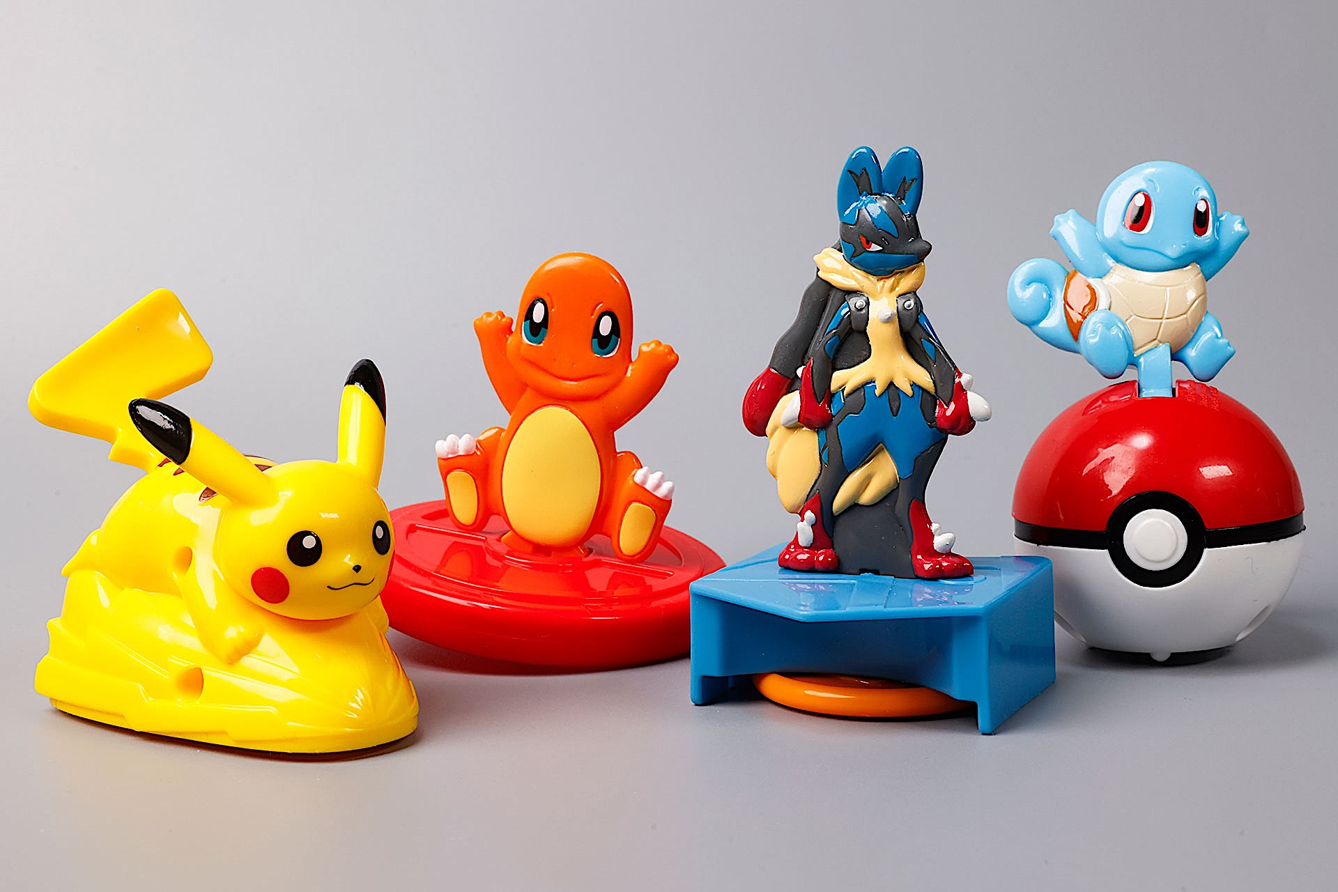 こちらが第1弾(8月8日〜8月14日)のハッピーセット「ポケモン」に登場するおもちゃ。写真左から「ピカチュウのしっぽフリフリダッシュ」、「ヒトカゲのくるくるスピナー」、「メガルカリオの飛び出すバトルディスクランチャー」、「ゼニガメのモンスターボールローラー」