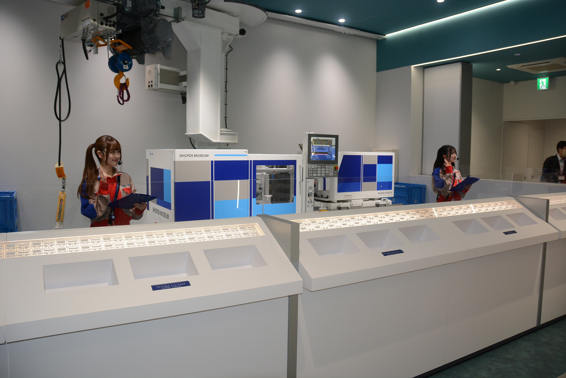 本物の射出成形機を前にプラモデルの生産過程を学ぶ