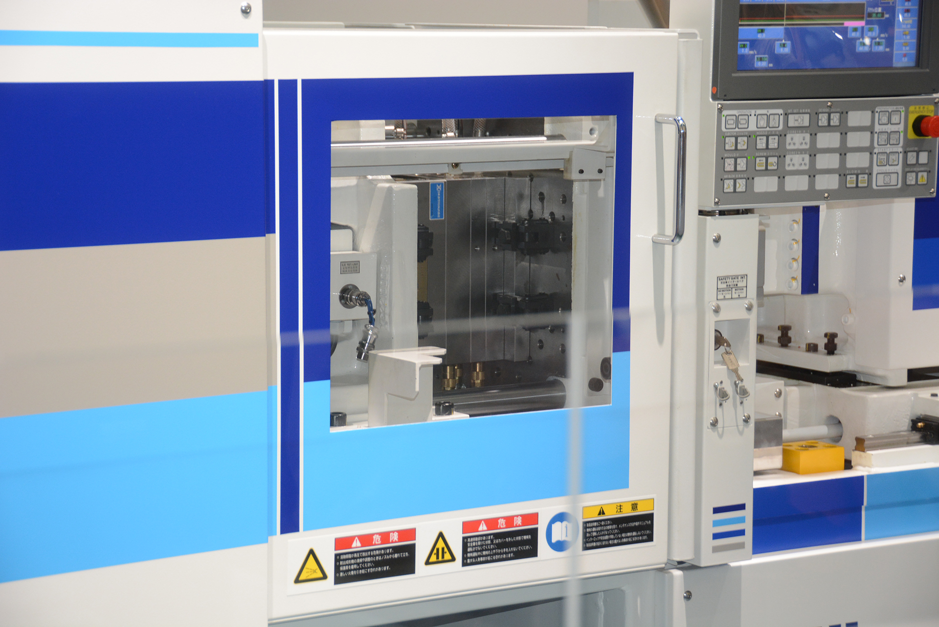 本物の射出成形機を前にプラモデルの生産過程を学ぶ