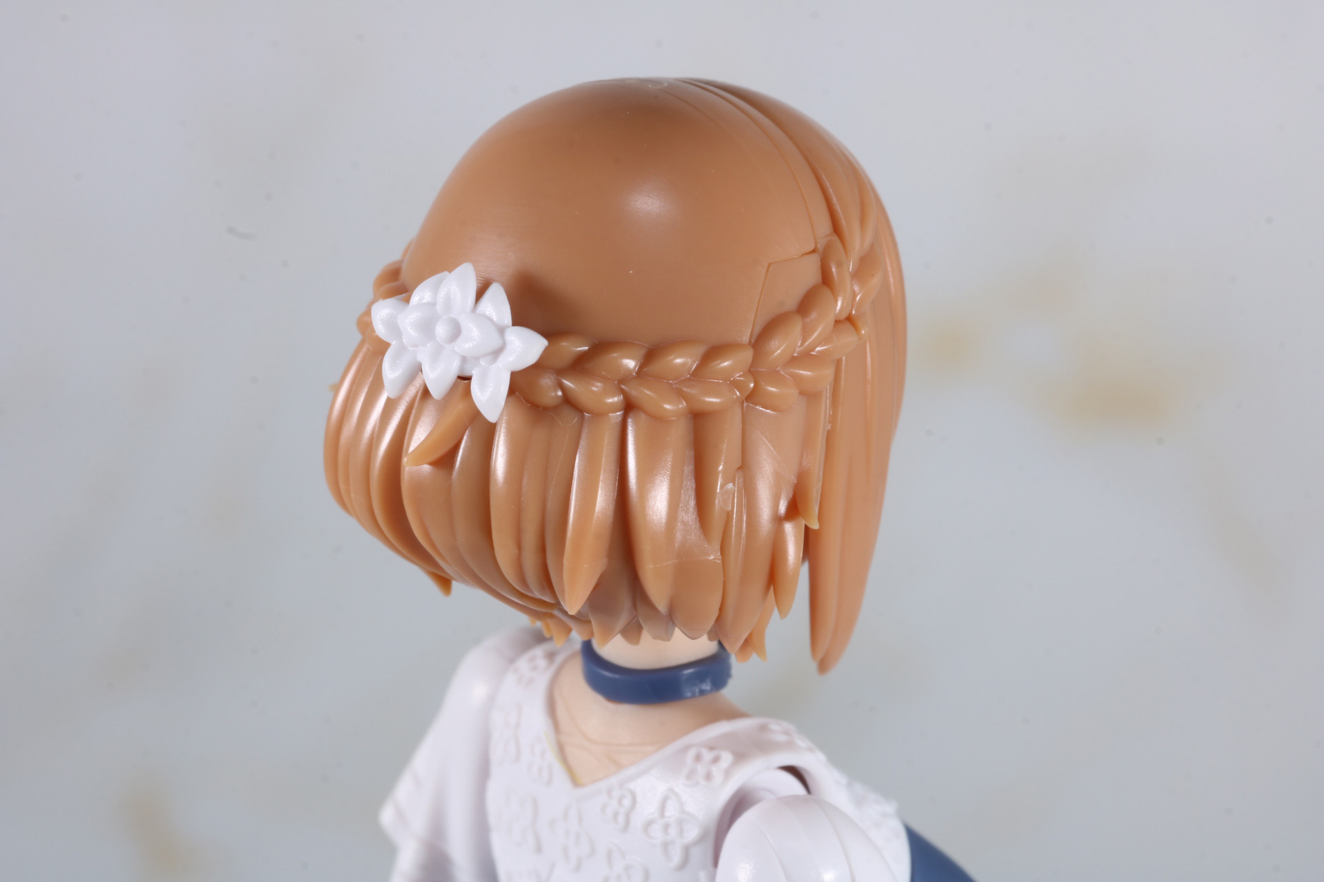 ヘアスタイルも編み込みや毛先まで繊細に造形。髪留めも花の造形となっている