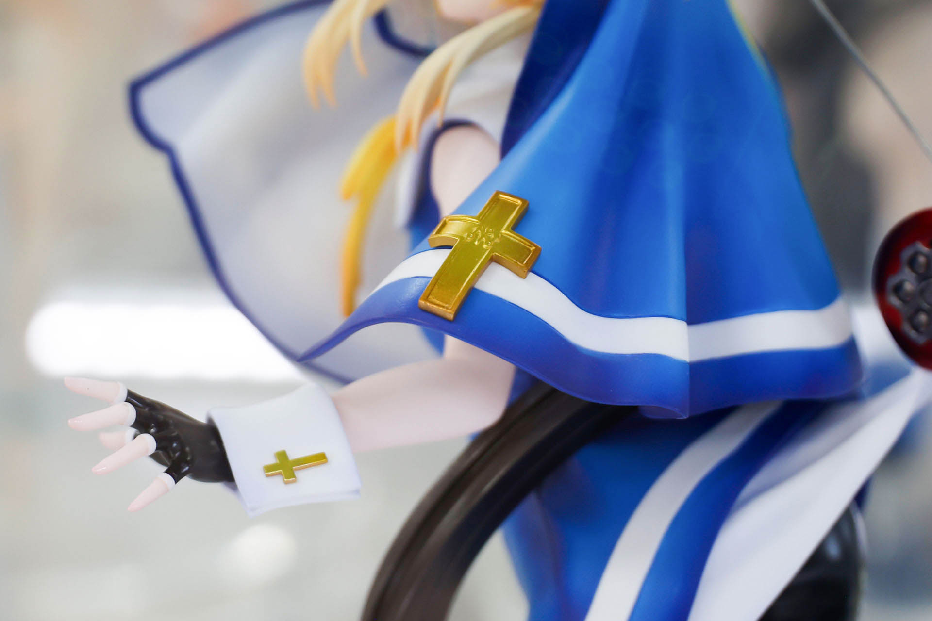 腕にも十字が付けられたアクセサリーを身につけている