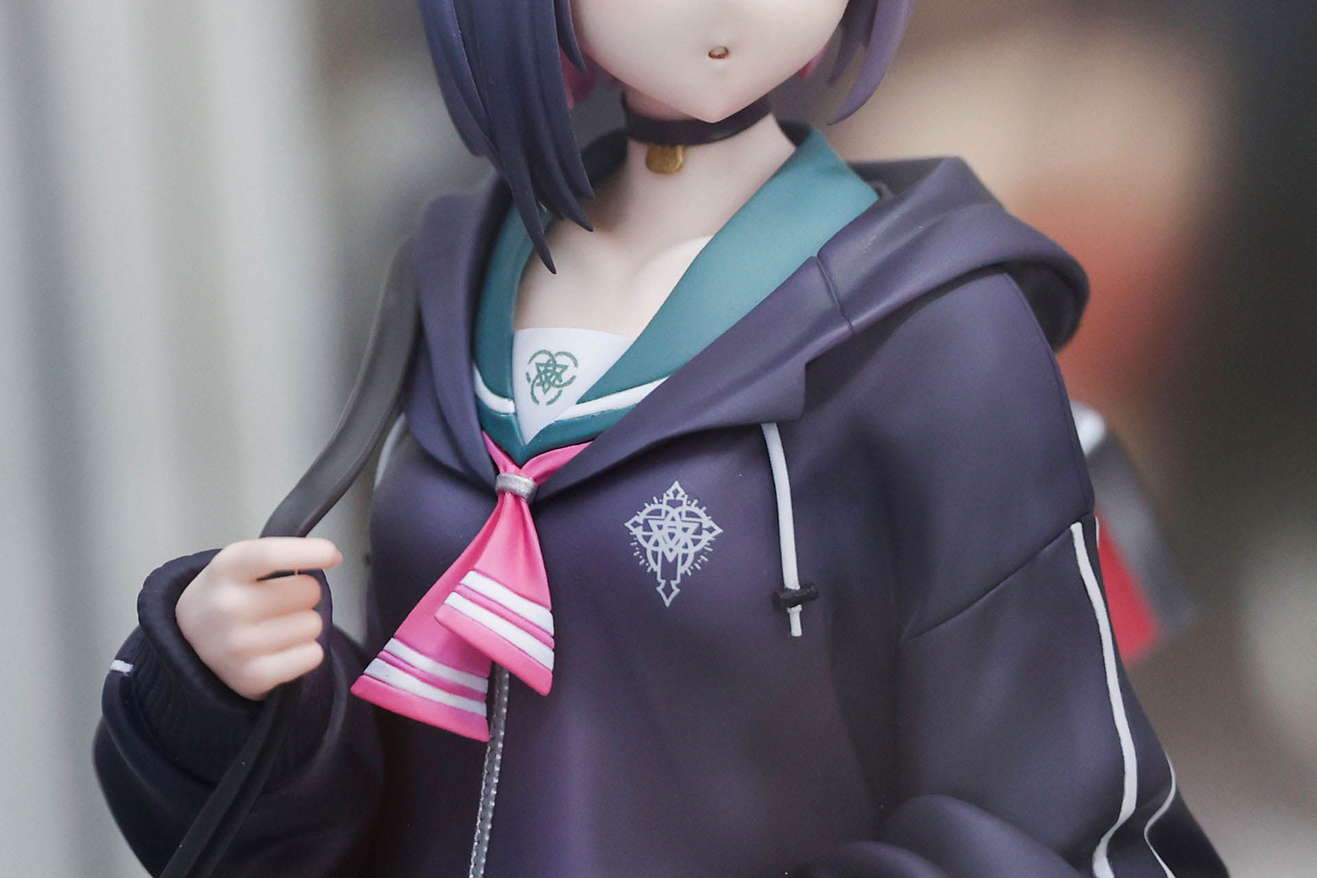 パーカーの胸元にはトリニティ総合学園のロゴマークが付けられている