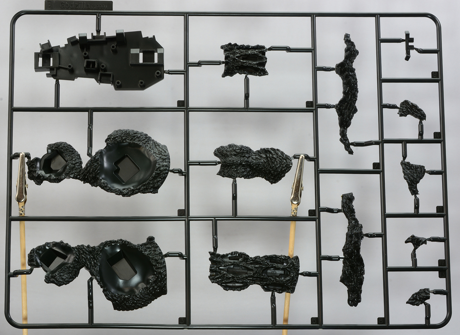 「PLAfig. ゴジラ (1999)」のランナーの一部。ゴジラの生物的な造形をプラモデルパーツで表現。成形色が黒なのもうれしいところだ