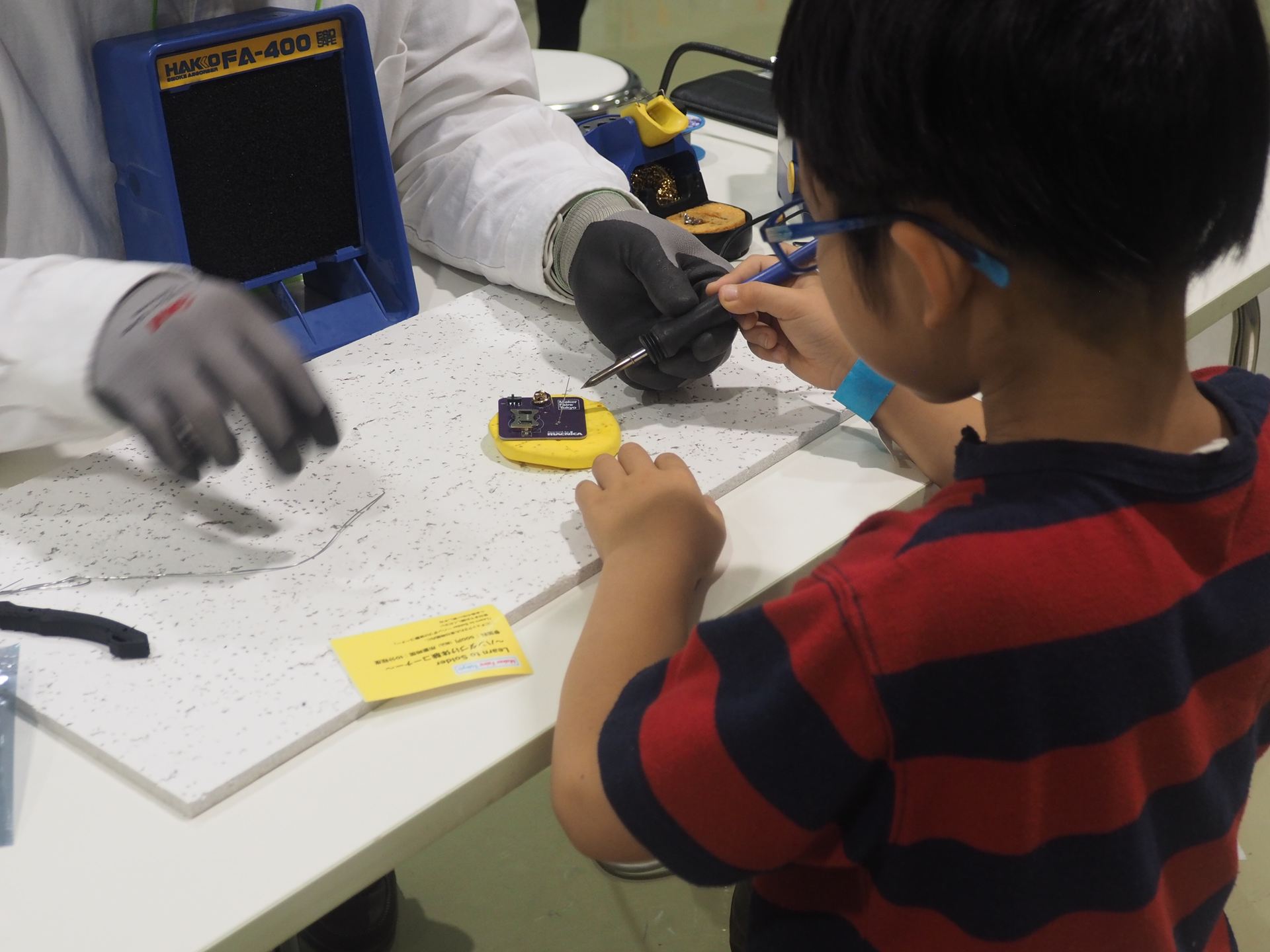 MakeyくんのLEDバッジをハンダづけで作っているところ。ハンダづけが初めてでも丁寧に指導してくれる