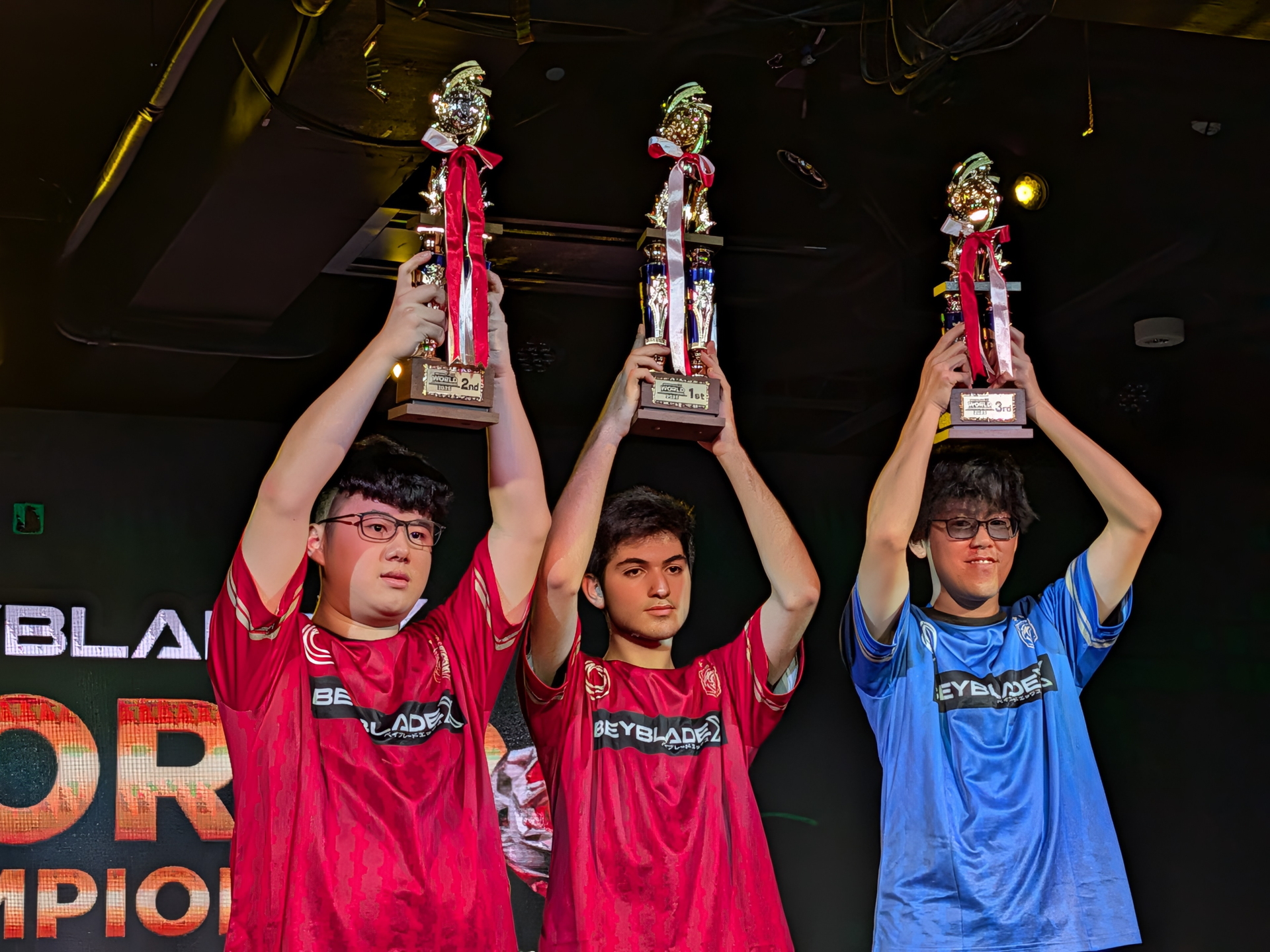 トロフィーを高々と掲げる3人