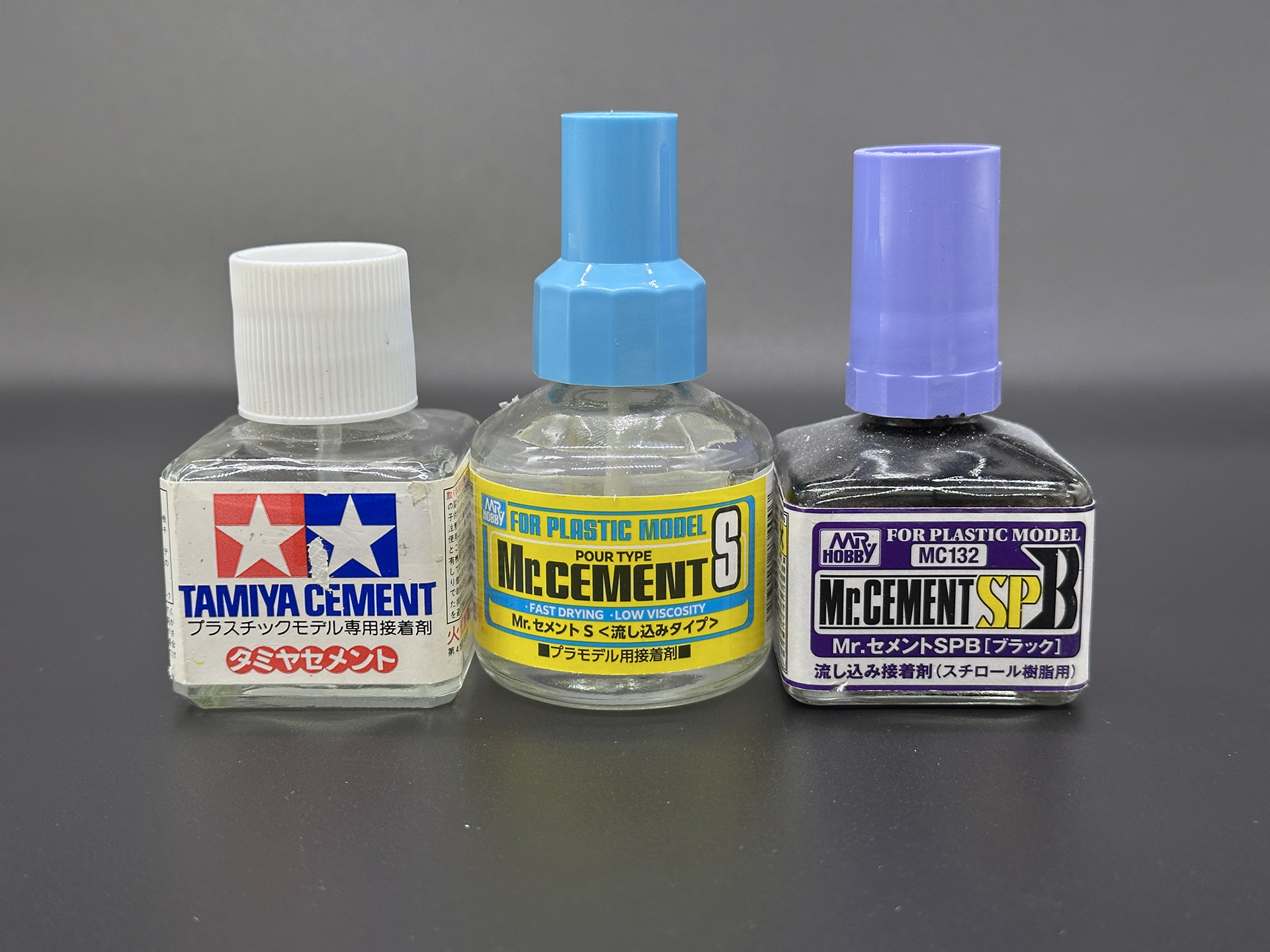 筆者の使用した接着剤。左からタミヤの「タミヤセメント (角びん)」、GSIクレオスの「Mr.セメント(流し込みタイプ)」、「Mr.セメントSPB(ブラック）」。筆者は普段からこれら3種類を愛用しています