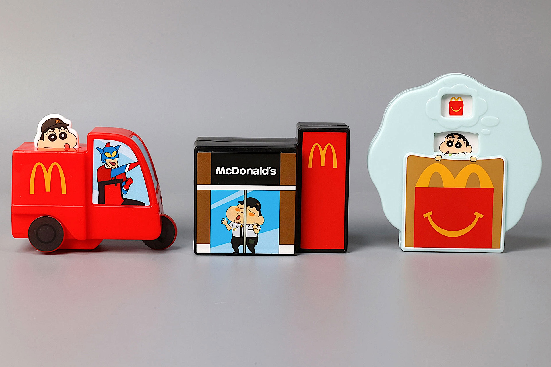 こちらが第2弾（1月23日〜1月29日）のハッピーセット「クレヨンしんちゃん」に登場するおもちゃ。写真左から「おまたせ！しんちゃんマックデリバリー」、「マクドナルドでカードパーティーだゾ！」、「ハッピーセットでゆめみるしんちゃん」