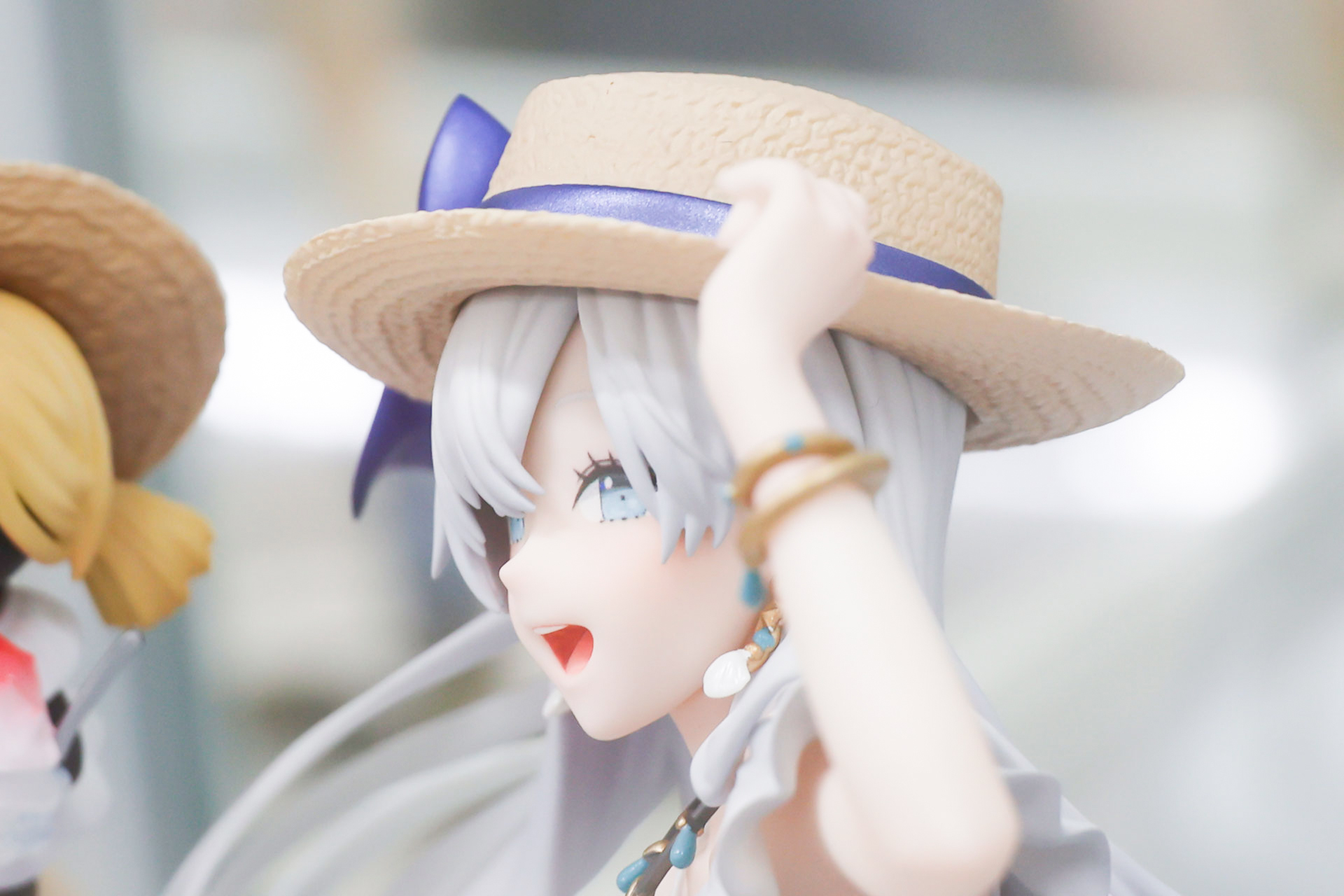 手で麦わら帽子を押さえている