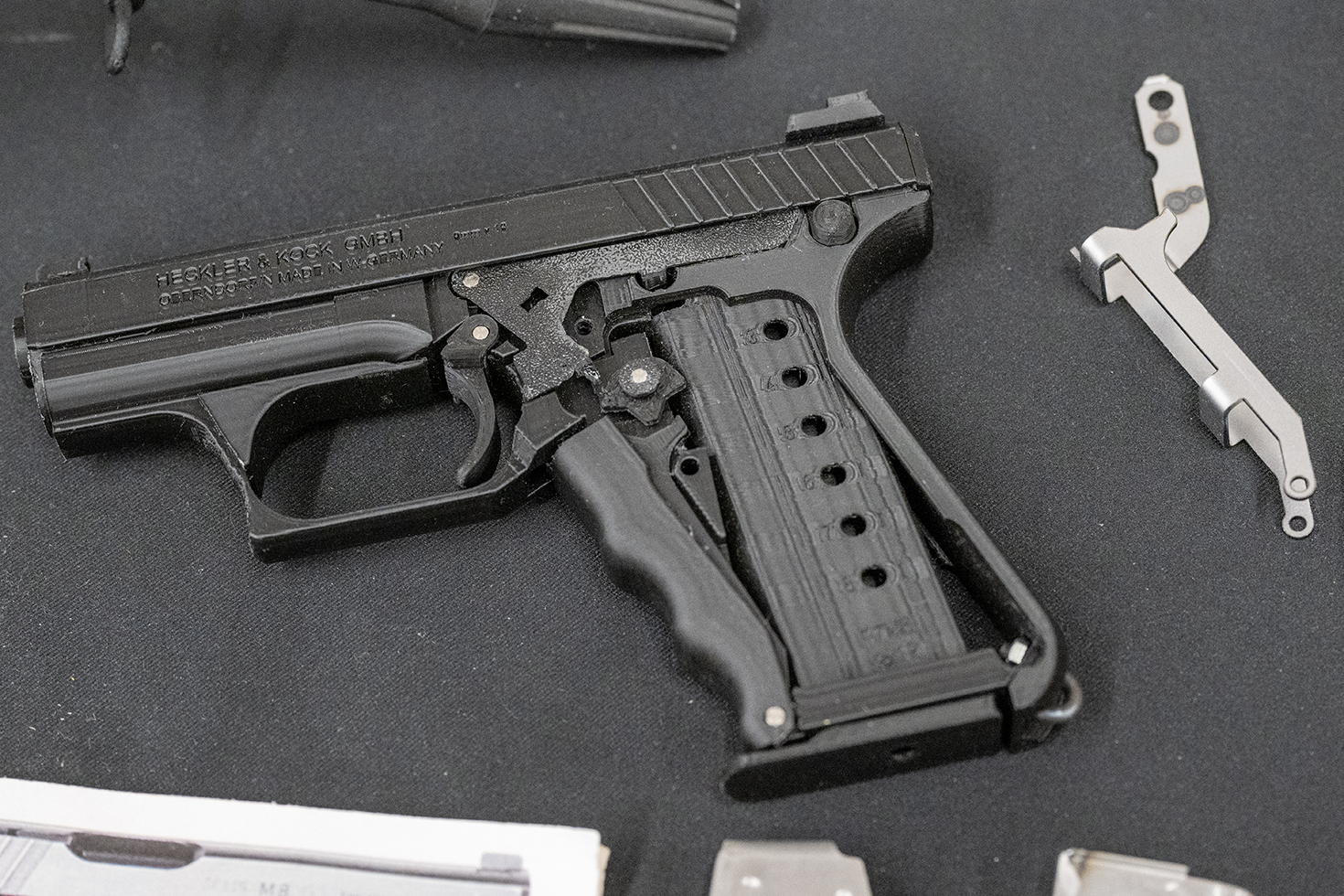 発売間近？　のH&K P7M8のパーツ展示。マガジンとスクイズ・コッカーの動きを伝える「ドラッグ・レバー」のサンプルが展示されていた