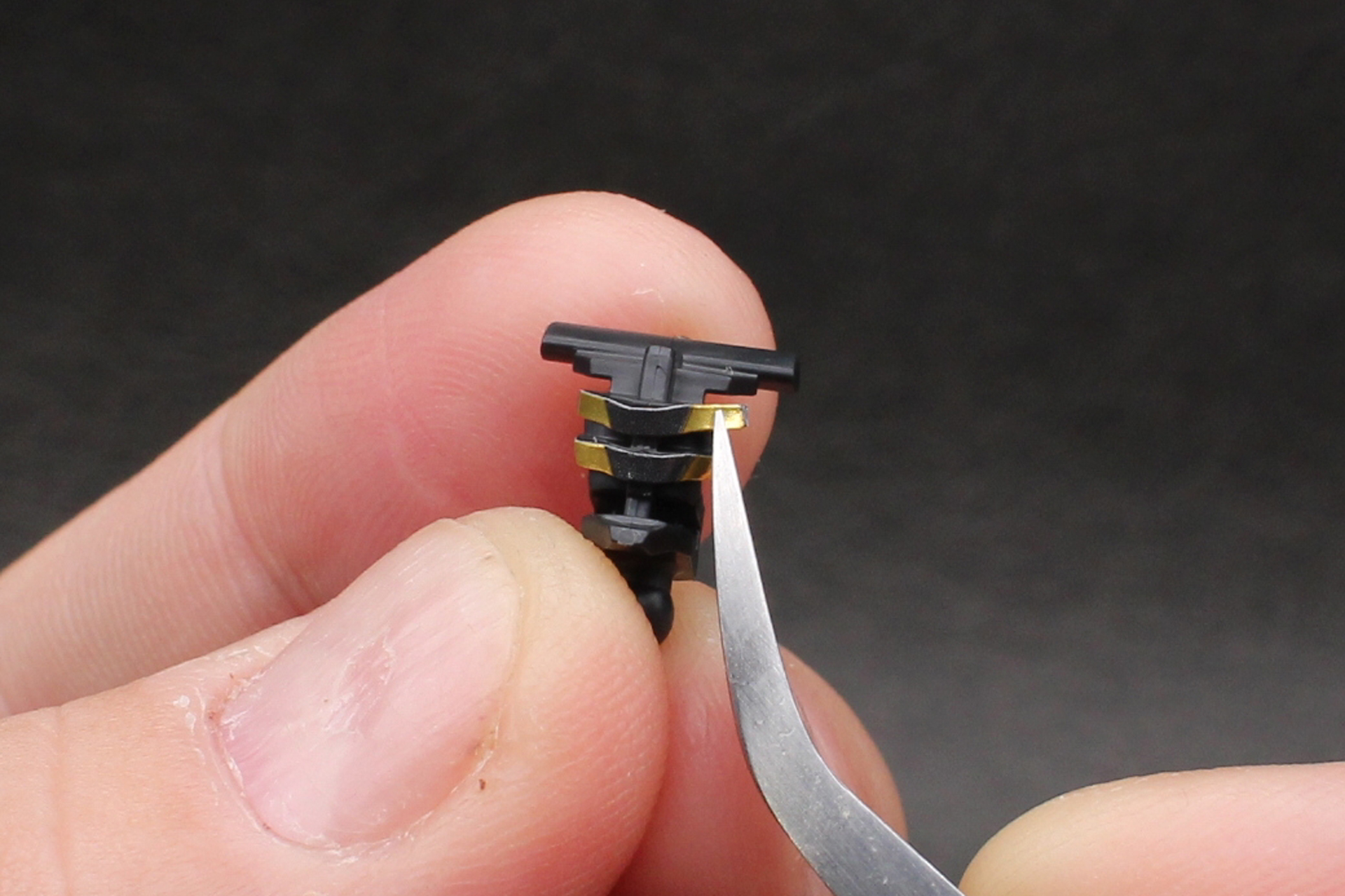 頭部の組み立て。バイザー内のカメラアイを表現するシールを貼る。他の部位も含め、綺麗に貼るにはピンセットを用意したい