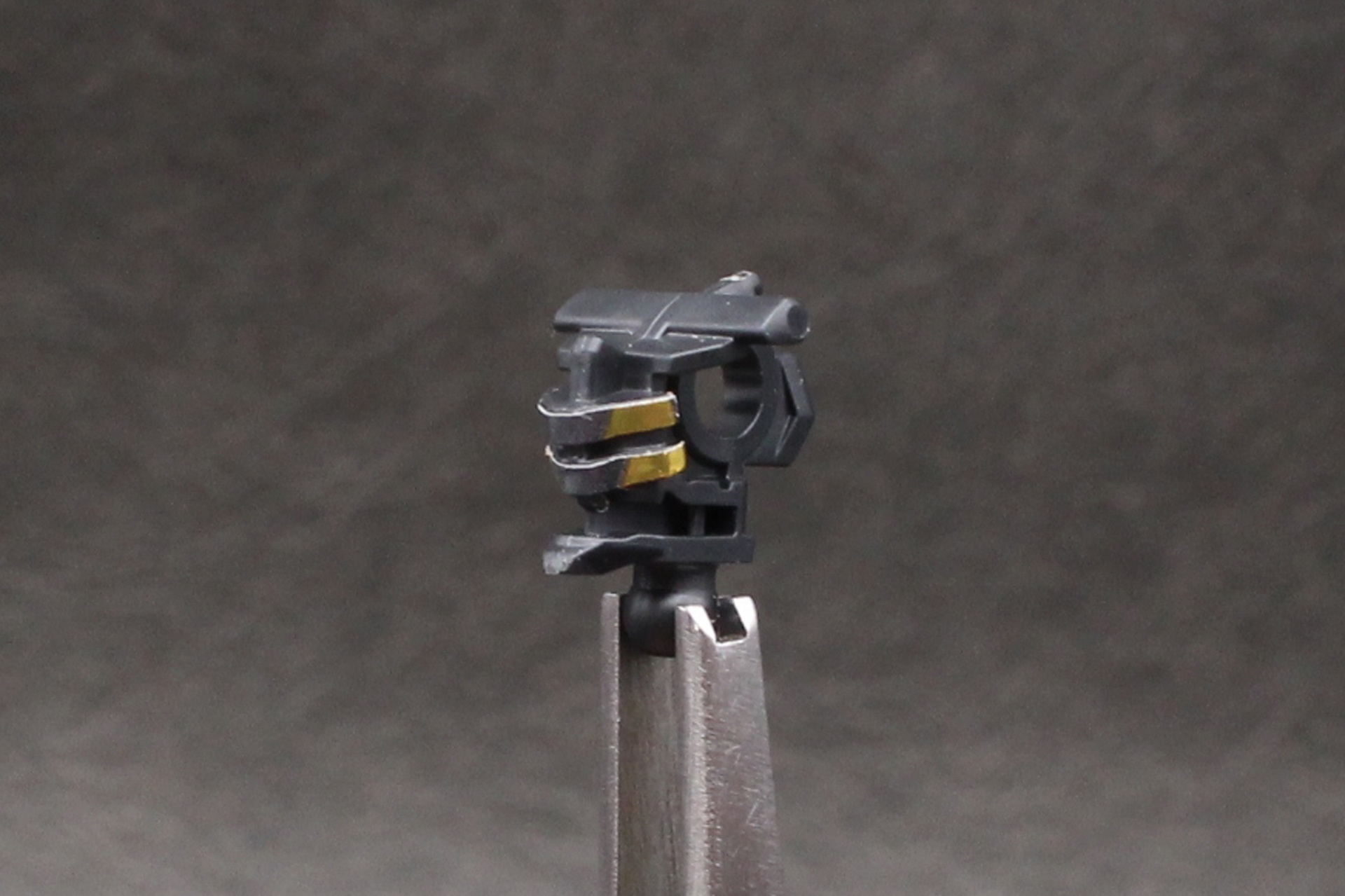 頭部の組み立て。バイザー内のカメラアイを表現するシールを貼る。他の部位も含め、綺麗に貼るにはピンセットを用意したい