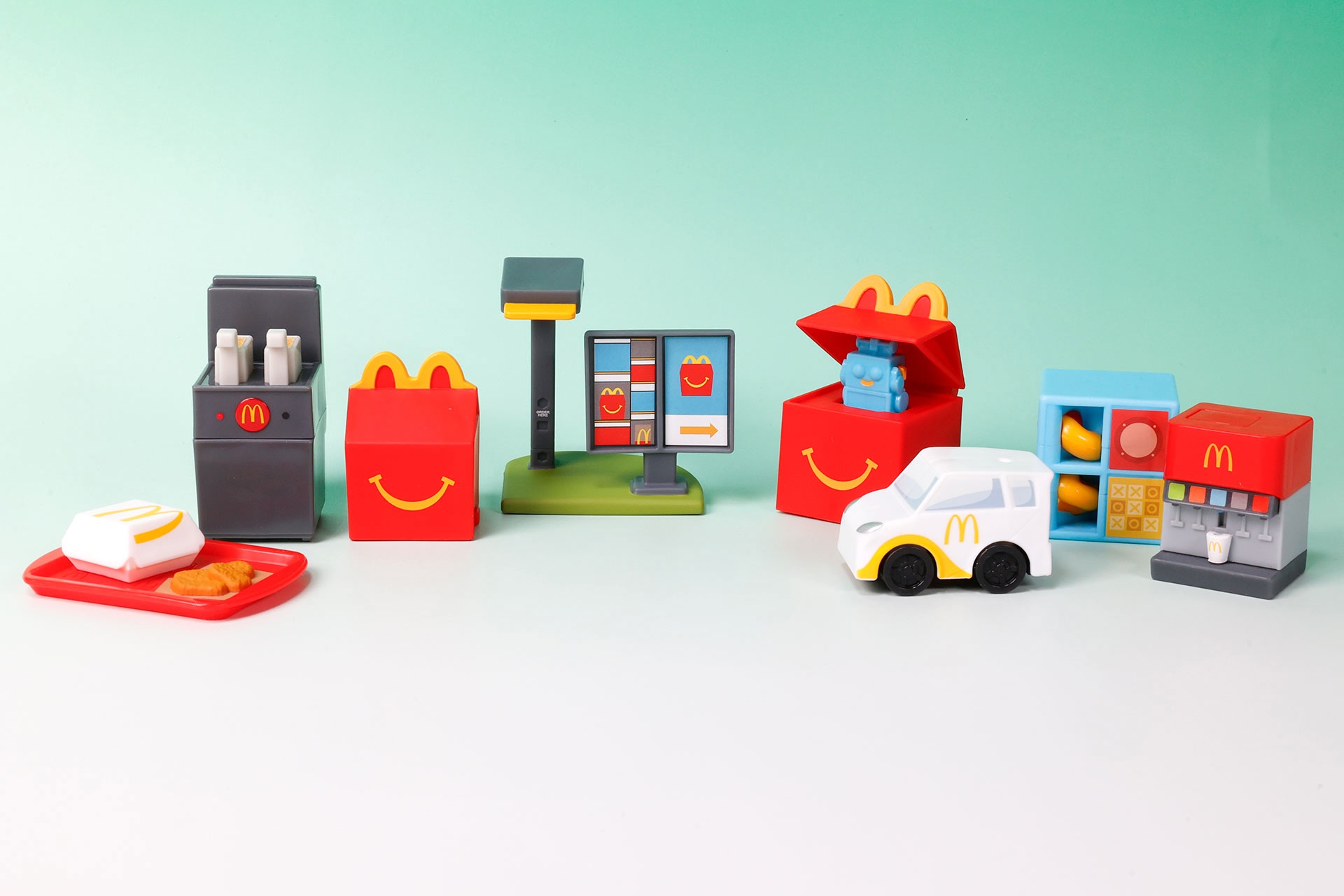 こちらが第2弾（3月6日〜3月12日）のハッピーセット「ミニチュアマクドナルド」に登場するおもちゃ。写真左から「チキンマックナゲット」、「マクドナルド ポテトフライヤー」、「ハッピーセットボックス」、「マクドナルド ドライブスルーメニューボード」、「ハッピーセット びっくりボックス」、「マクドナルドカー」、「マクドナルド プレイプレイス」、「マクドナルド ドリンクメーカー」
