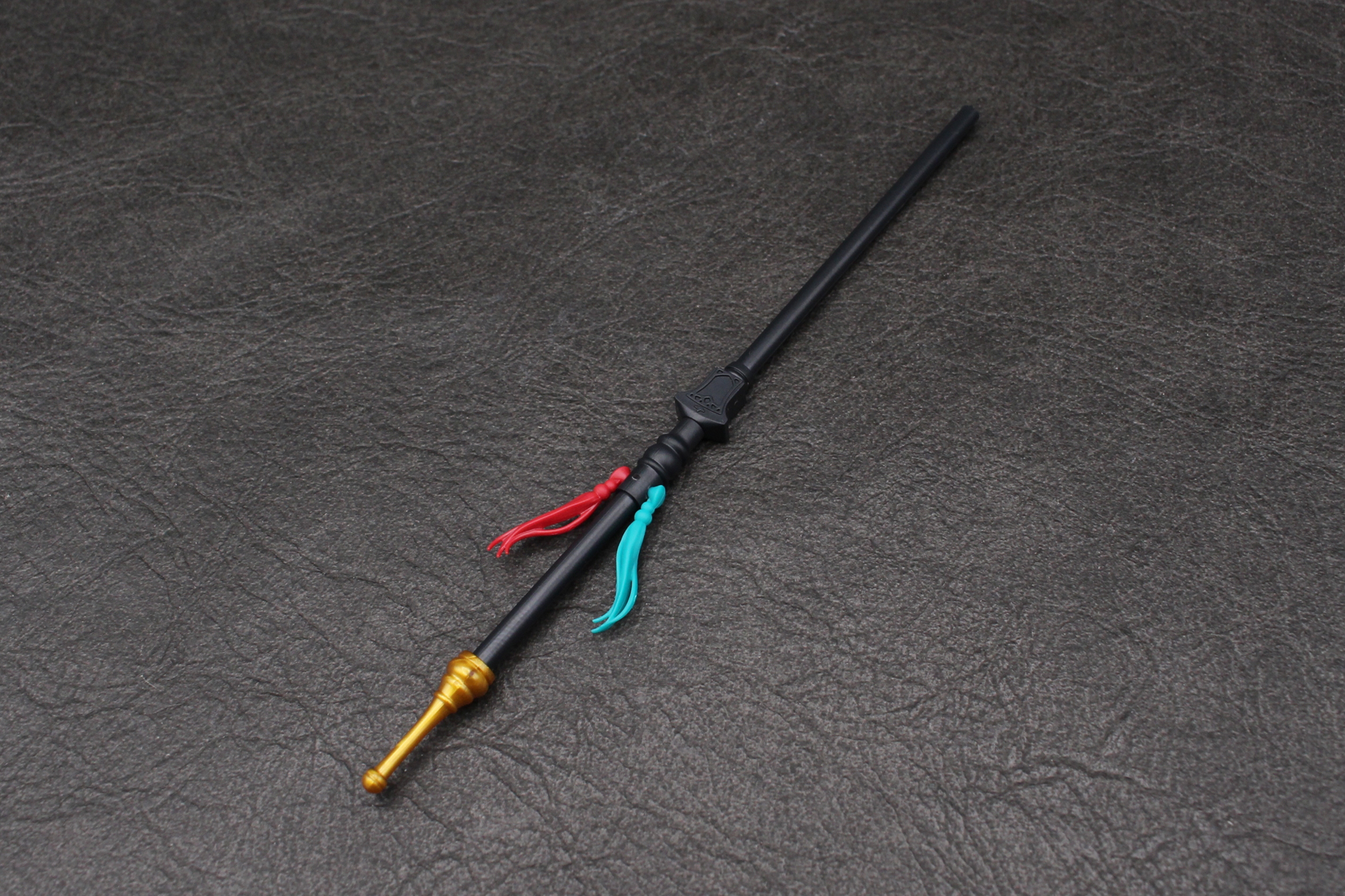 杖の柄を組み立てる。2色の飾りは付け根で可動する