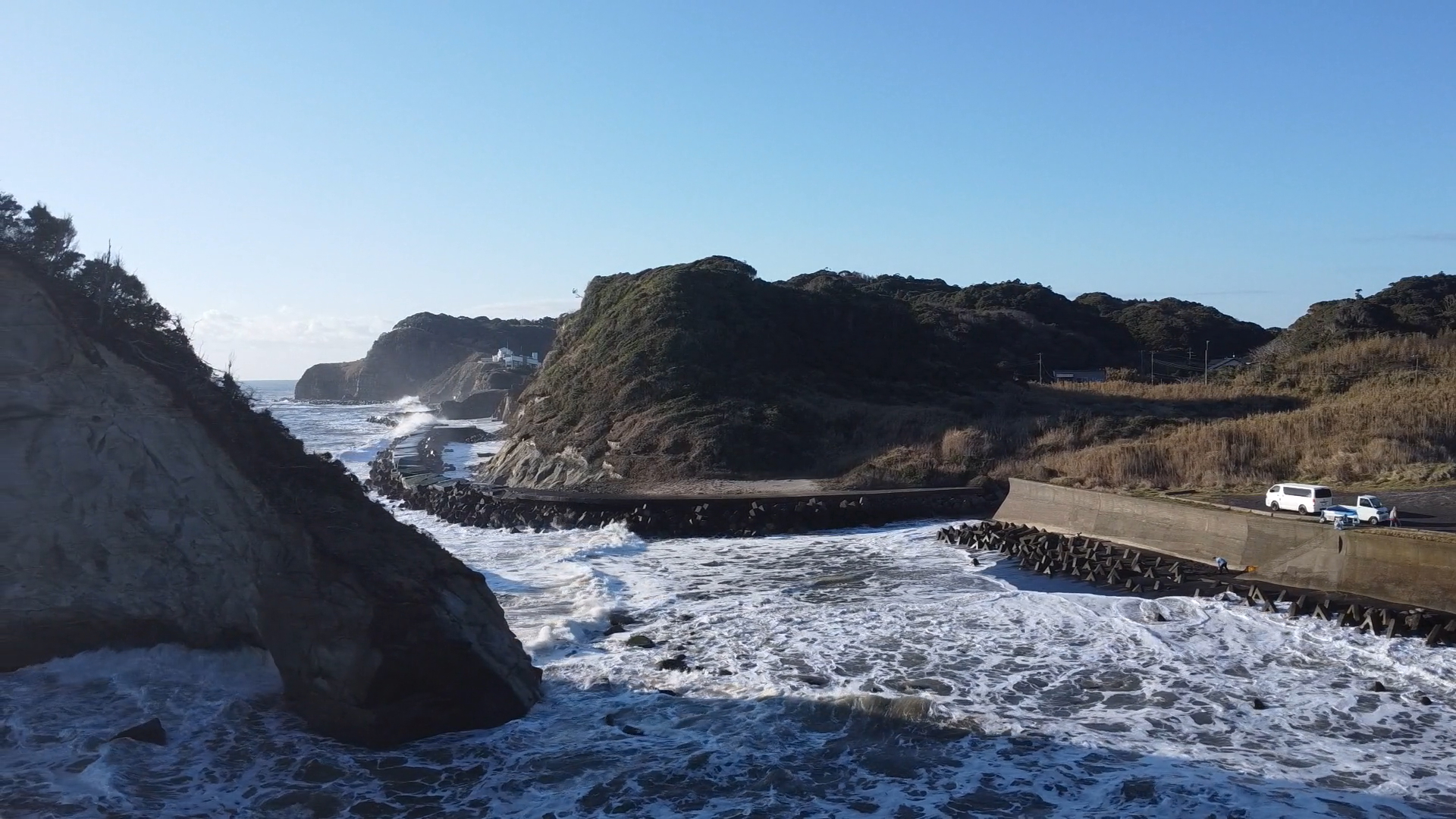 岸側にカメラを向ける。島の端まで100mほどだ。現在砂浜はほとんどなく、2024年から立ち入りには許可が必要になった。筆者は白い車があるあたりから操縦している