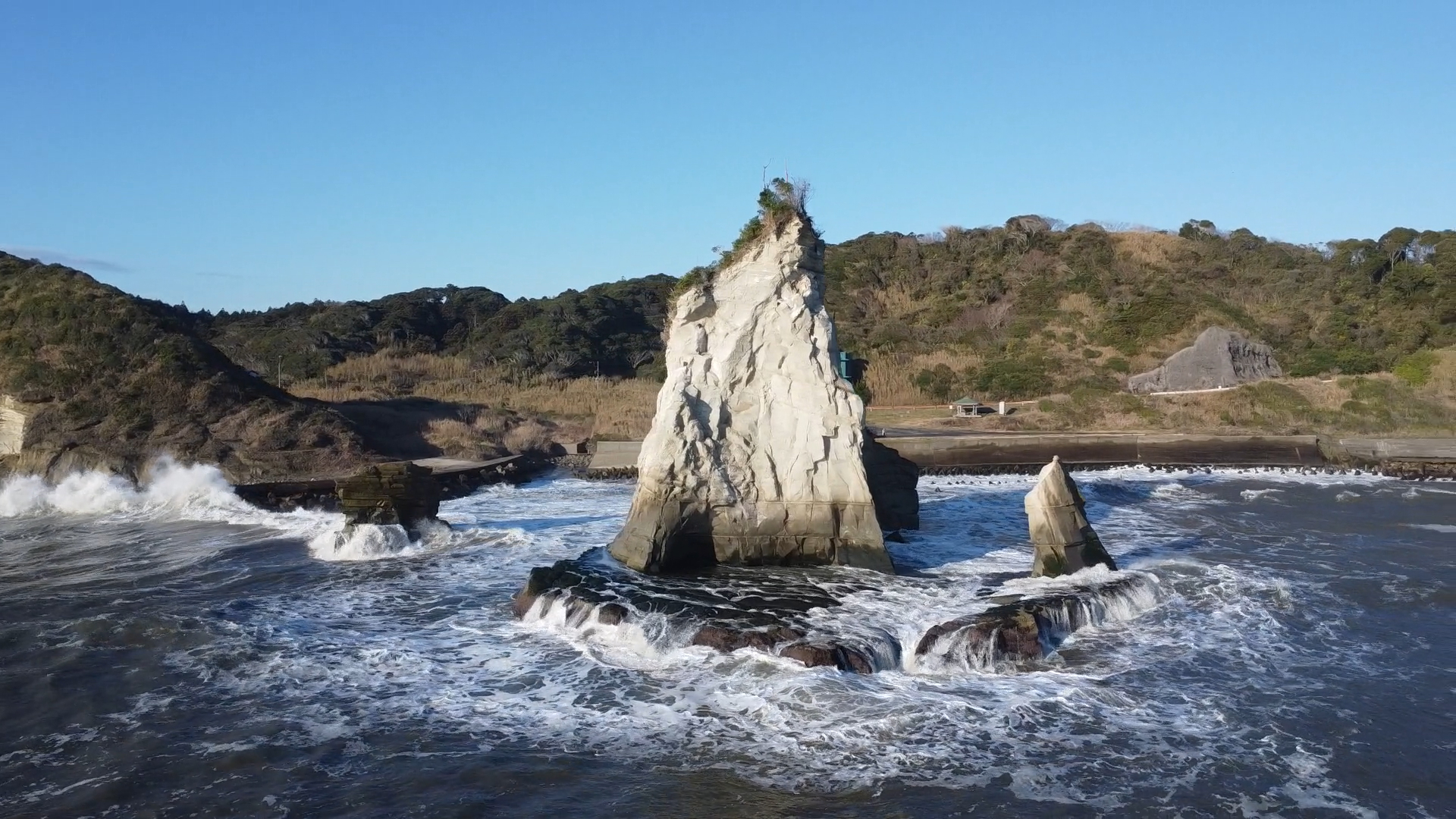 小島全体を映し出すため、引いた視点での撮影。完全に岸側から反対方向だ。奥に緑のビルが見えるが、津々ヶ浦周辺は知る人ぞ知る観光スポットで、カラフルな建物や、貸別荘などが建っている
