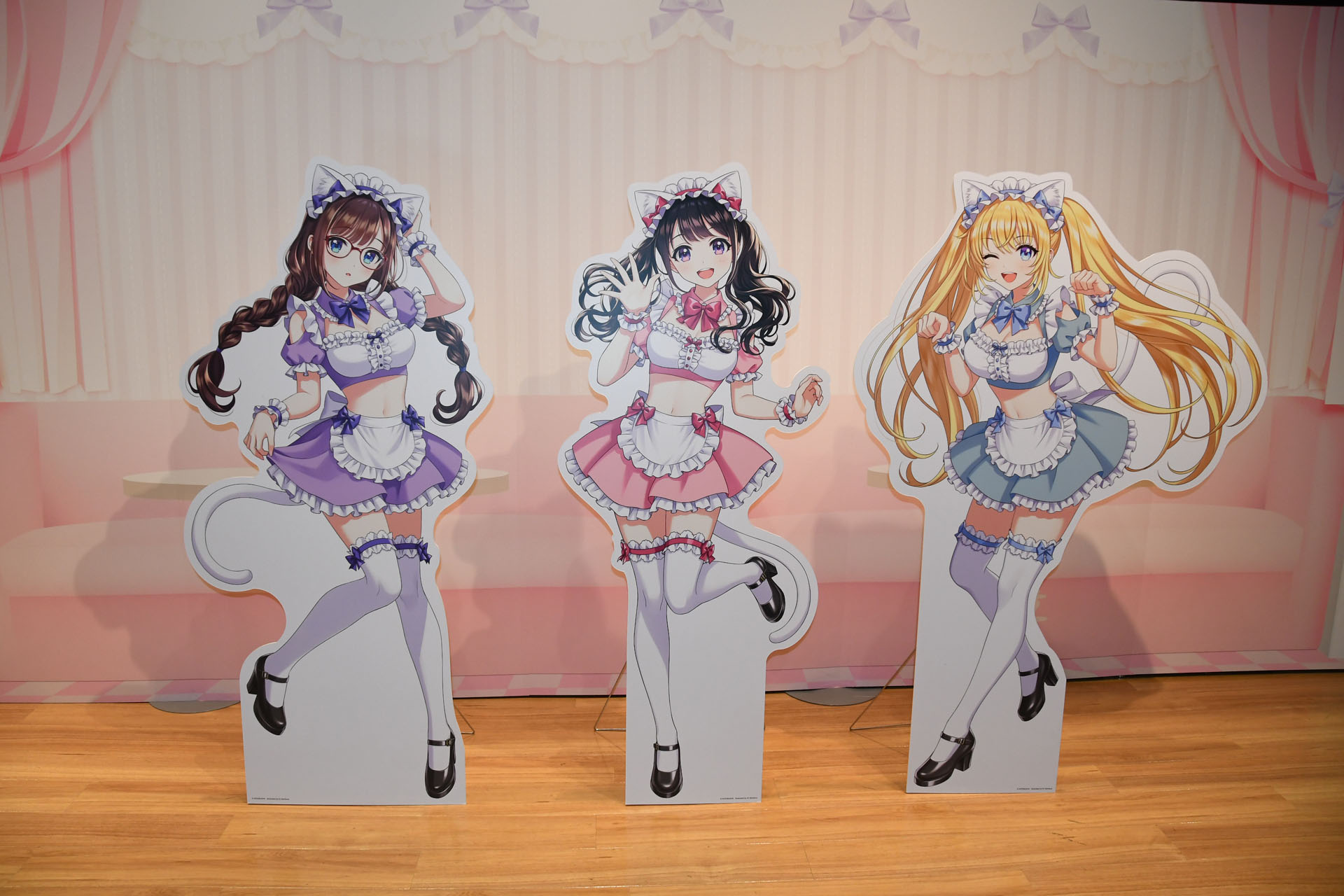 「創彩フェス 5th」の展示パネル。"合同学園祭"のテーマで学園祭定番の喫茶店での衣装という演出で飾られている。おなかがむき出しのセクシーな雰囲気もある